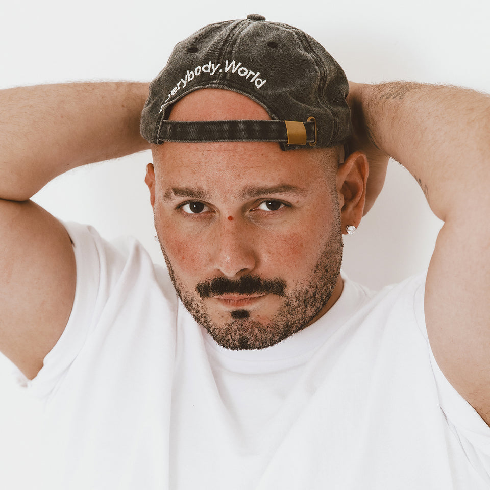 Man wearing a Bucky Logo Cap in Black with 'Everybody World' and White Boxier Trash Tee.