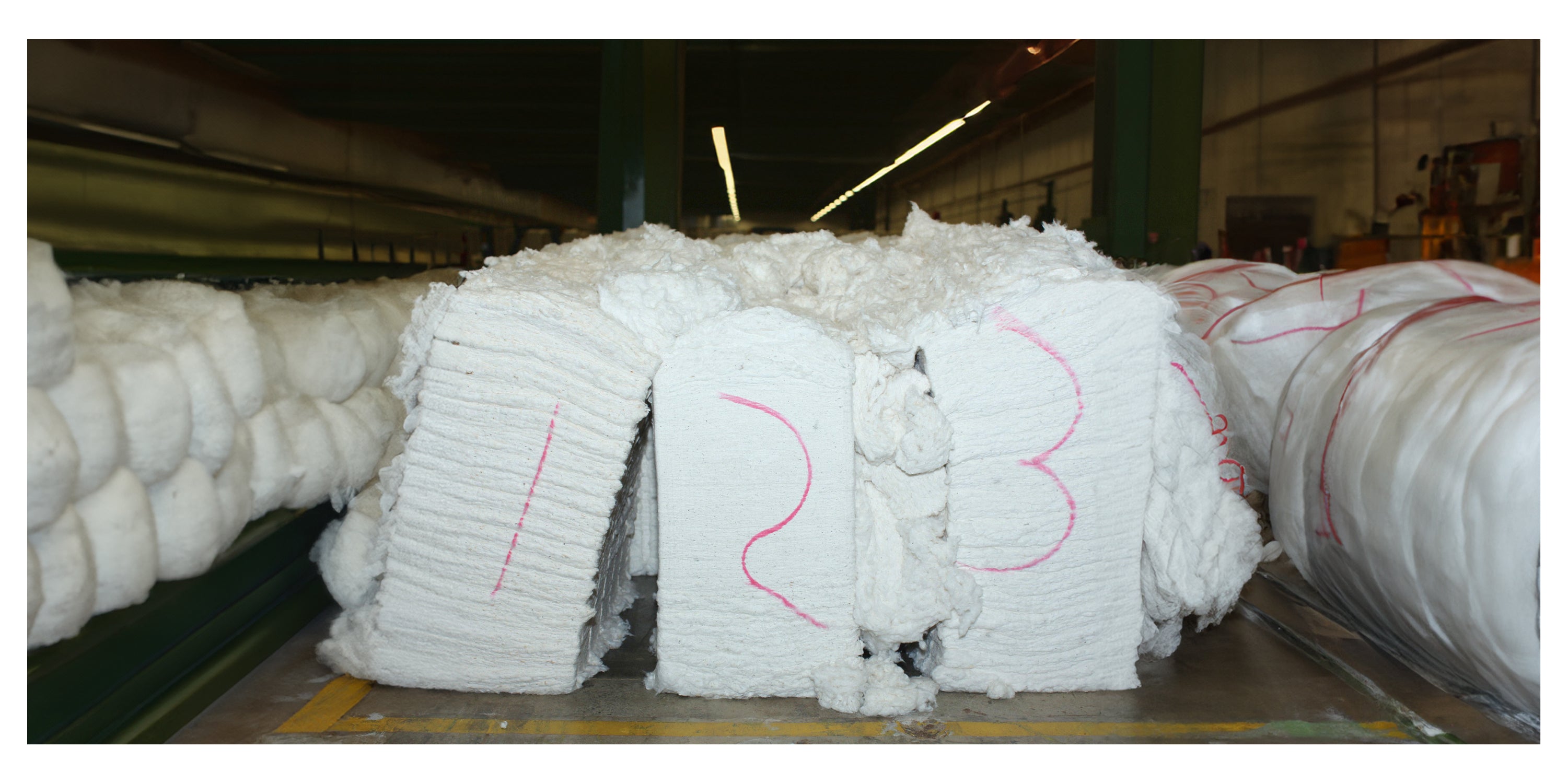 Bales of reclaimed waste cotton material in an industrial setting