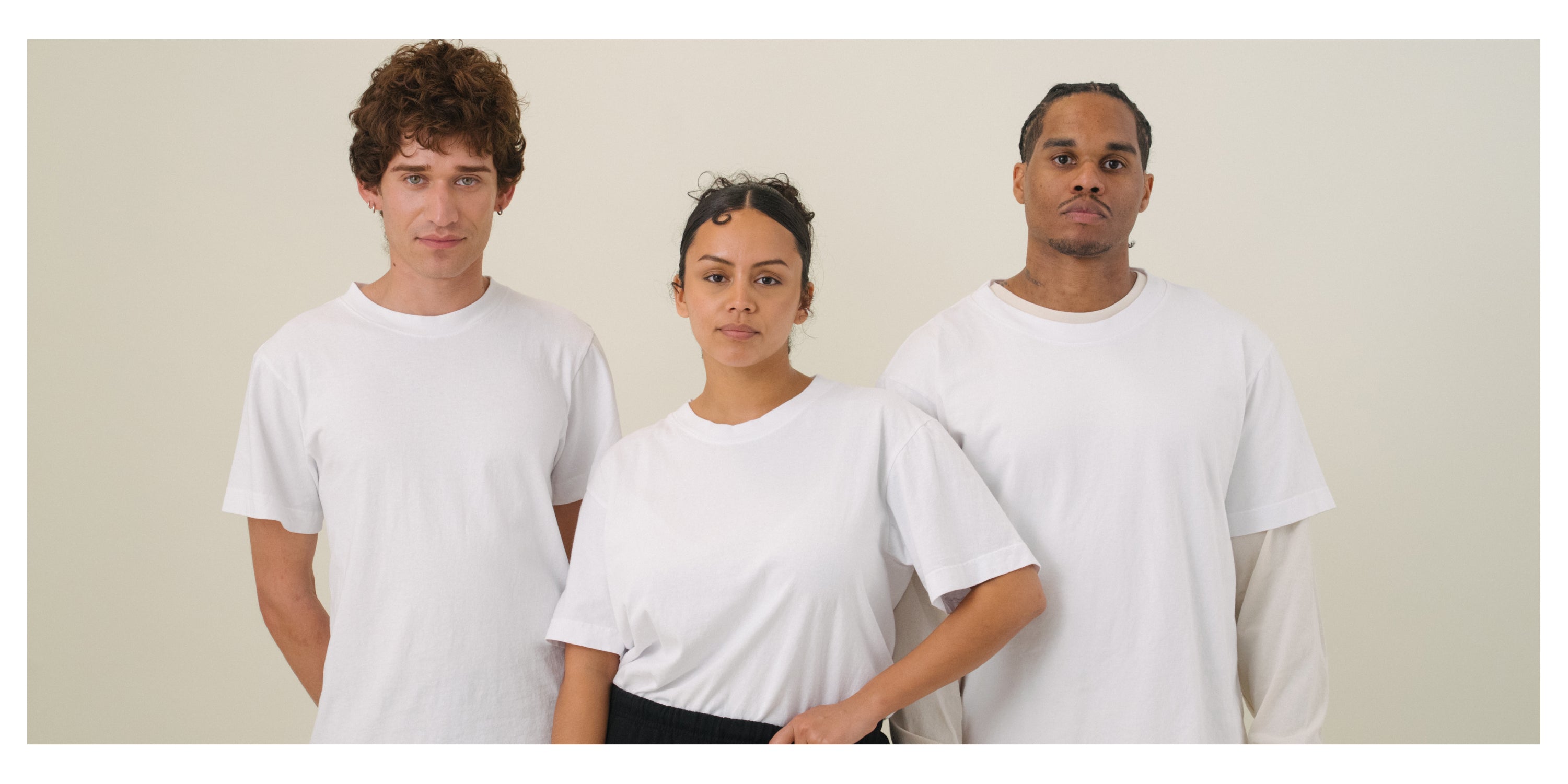 Three people wearing all wearing Trash Tees in White standing against a light background