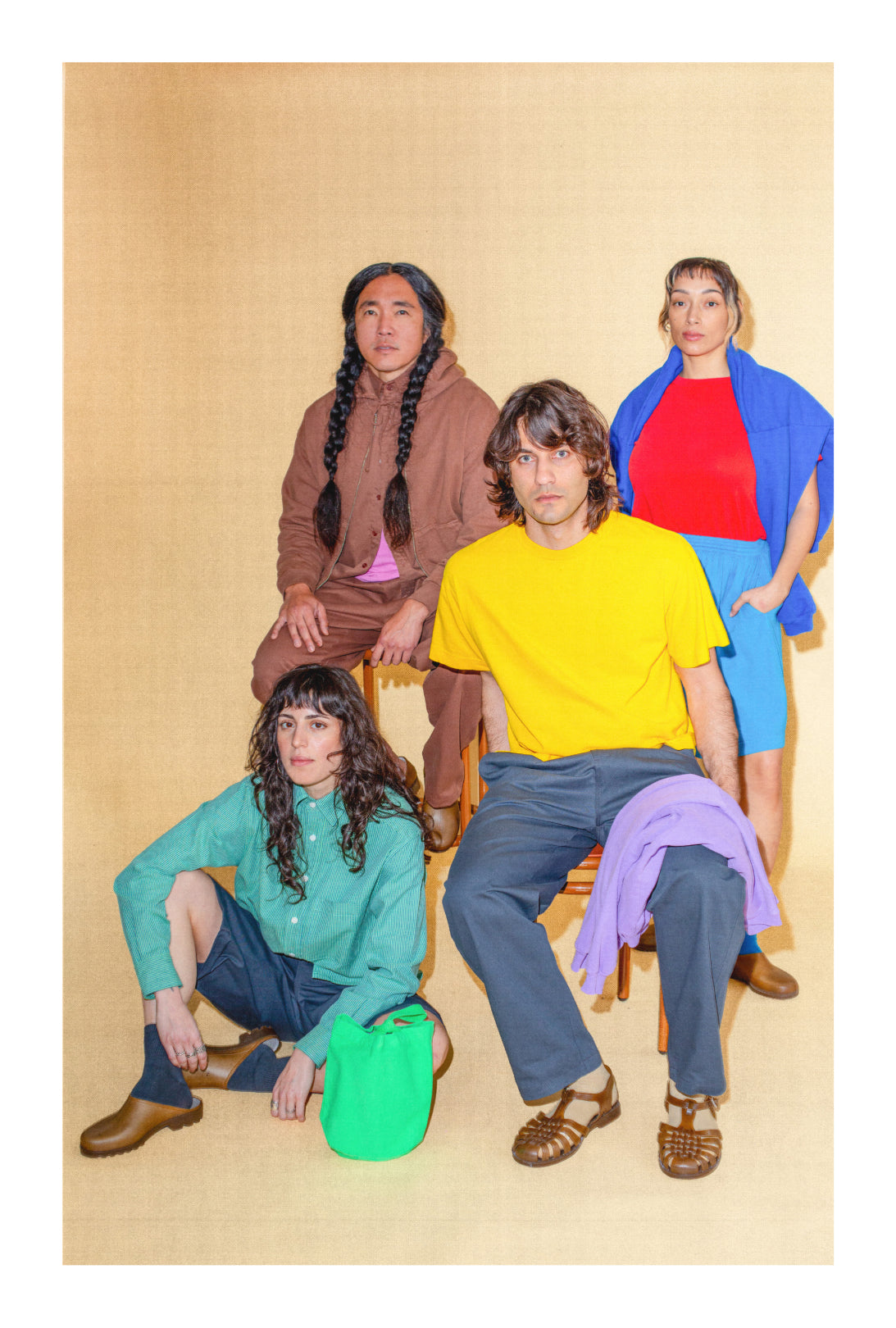 Four people in colorful Trash Collection clothing posing against a beige background