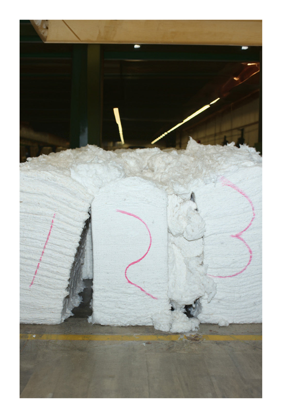 Bales of reclaimed waste cotton material in an industrial setting