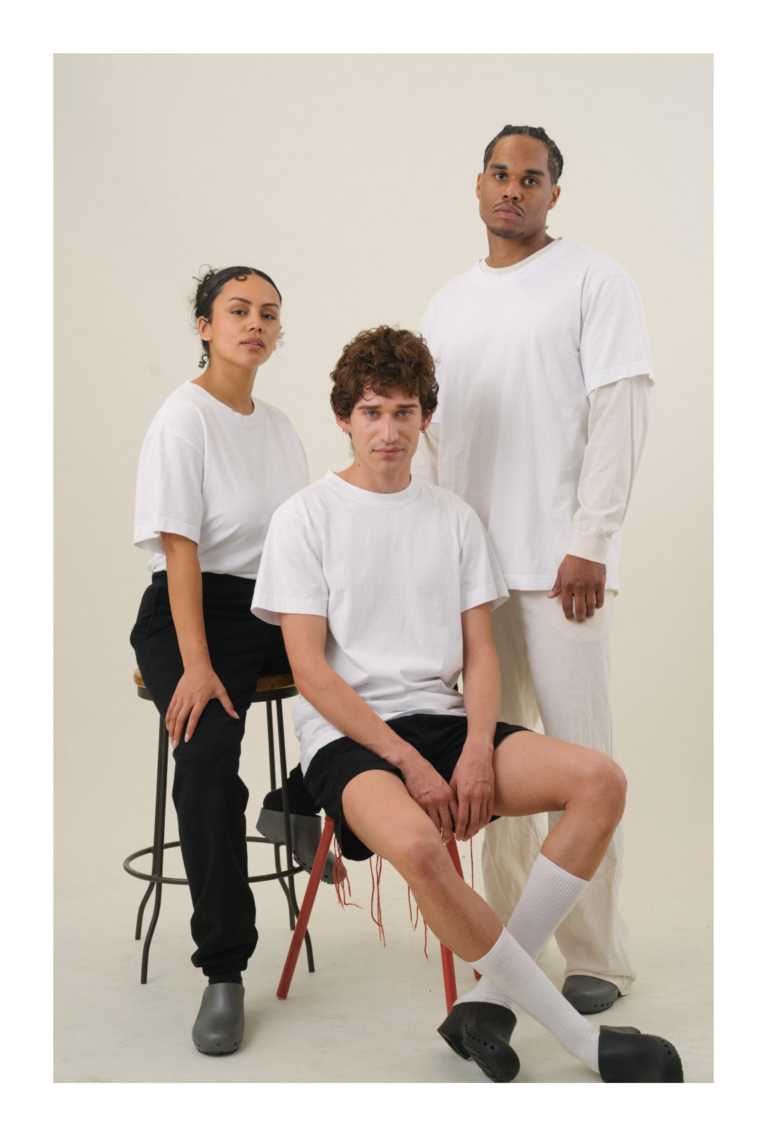Three people wearing all wearing Trash Tees in White standing against a light background