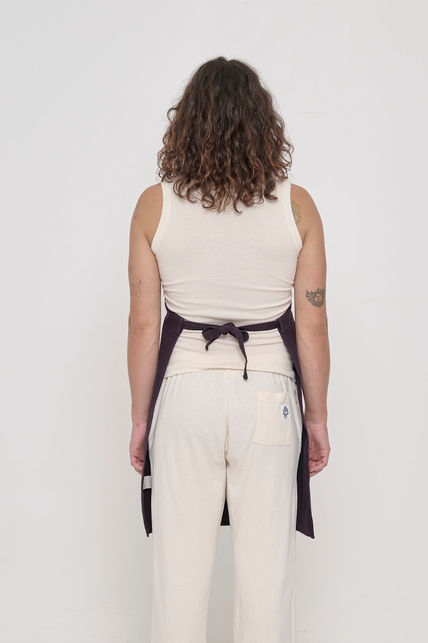 Rear view of a person in a Mulberry Adjustable Apron, showing the waist straps tied.