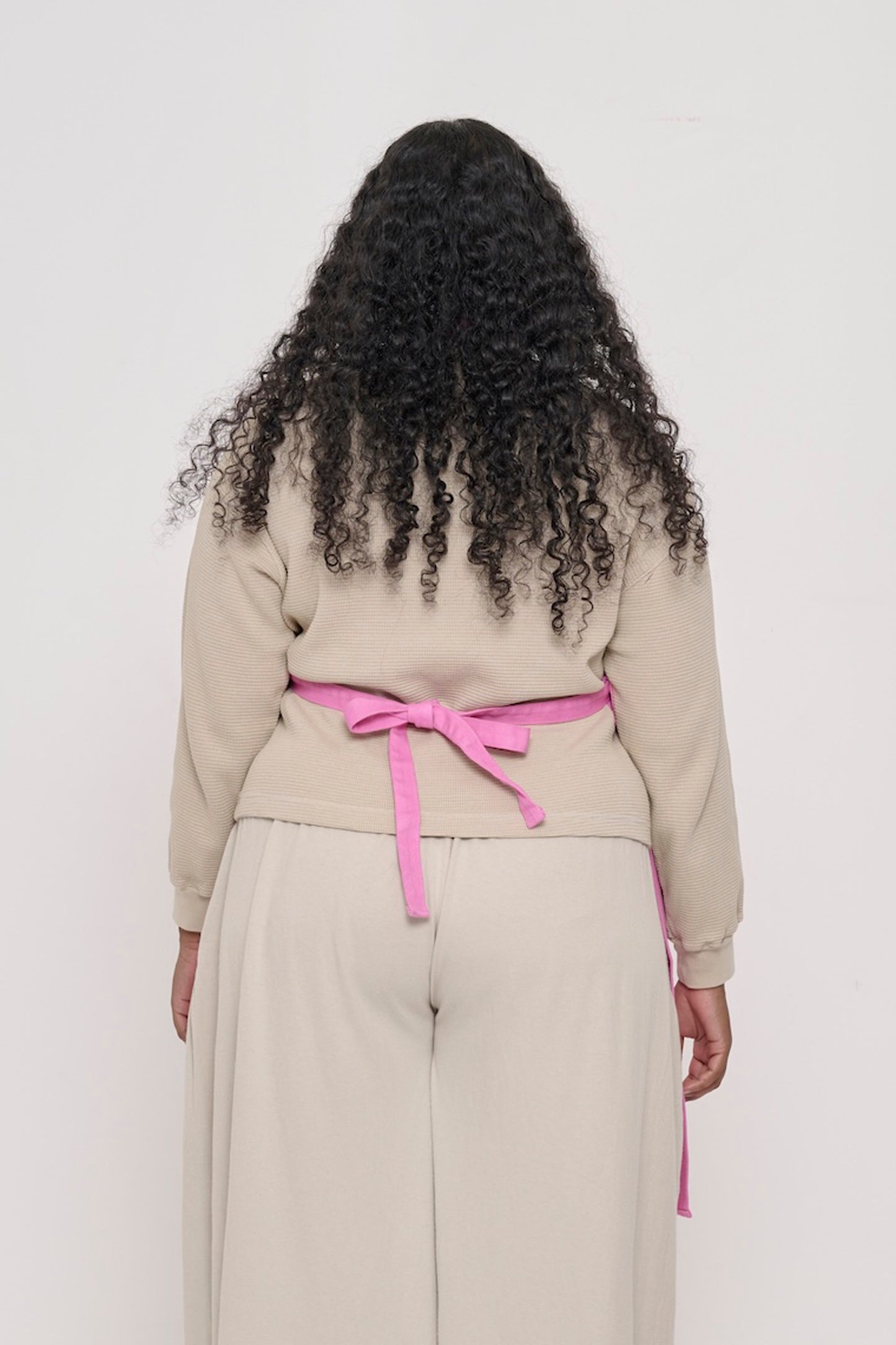 Rear view of a woman in a Pixie Adjustable Apron, showing the waist straps tied.