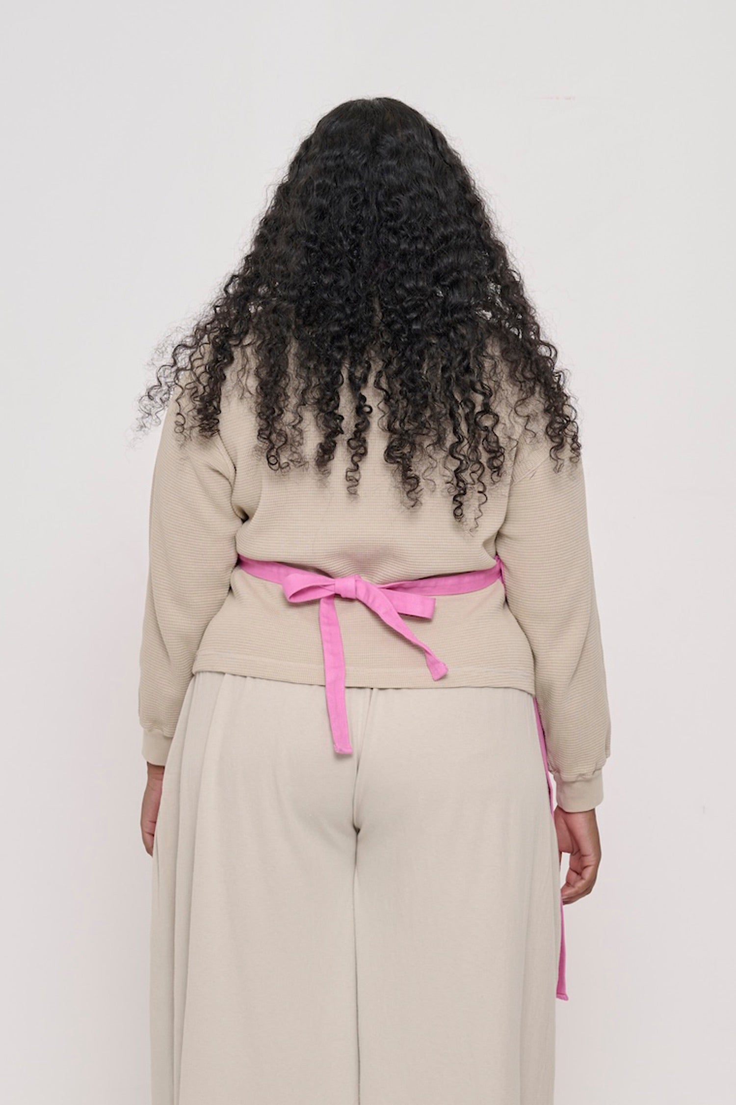 Rear view of a woman in a Pixie Adjustable Apron, showing the waist straps tied.