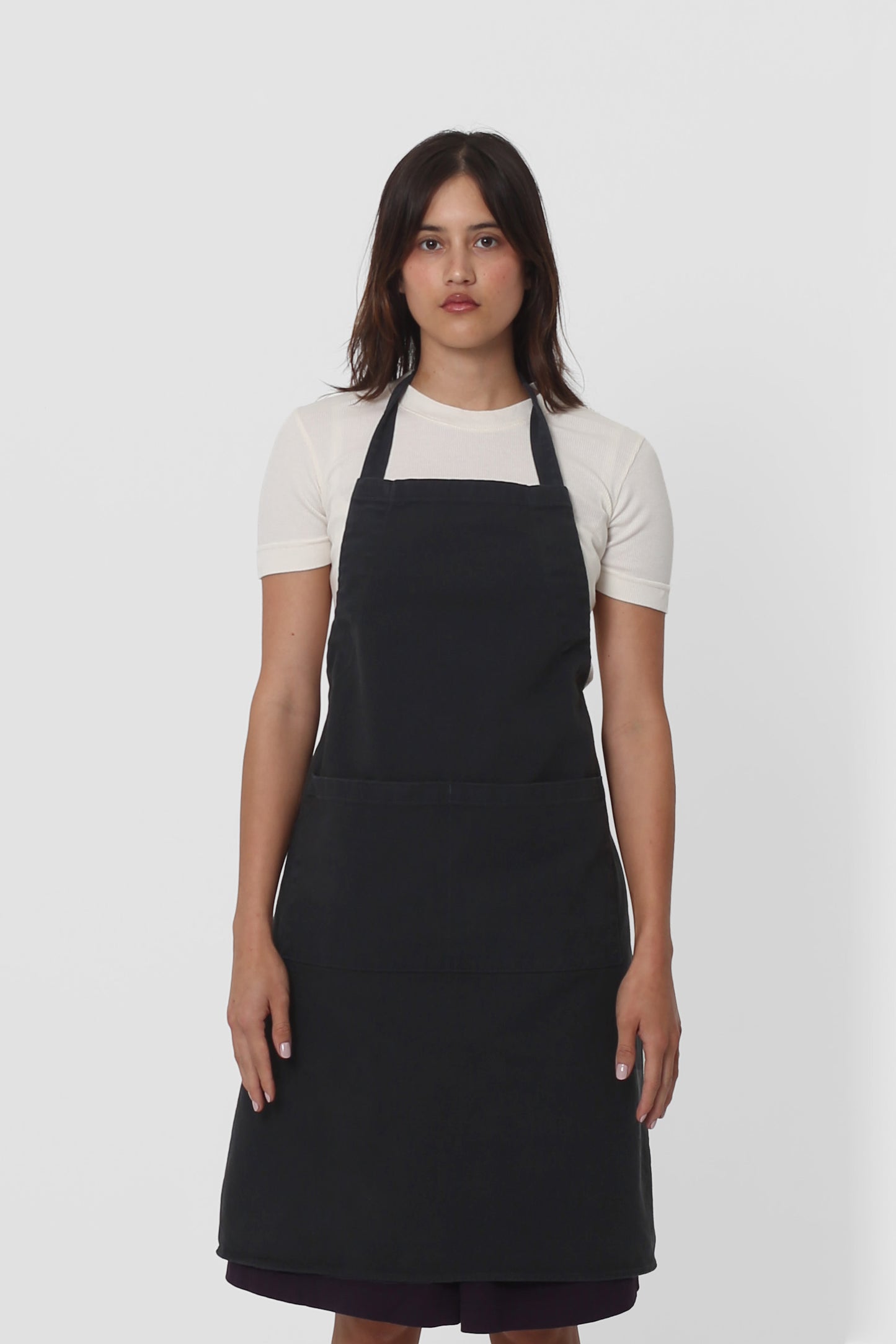 Front view: a woman in an Slate Adjustable Apron. Straps tied behind her back.