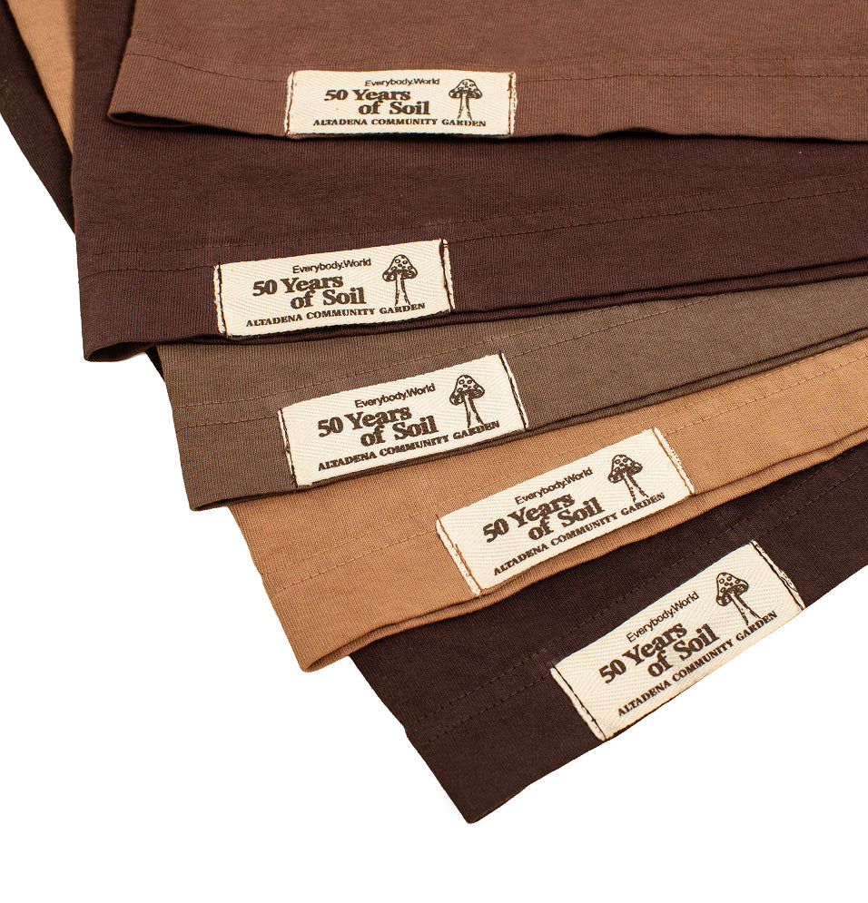 Detail photo of the labels on the five shades of "50 Years of Soil" Boxier Trash Tees.