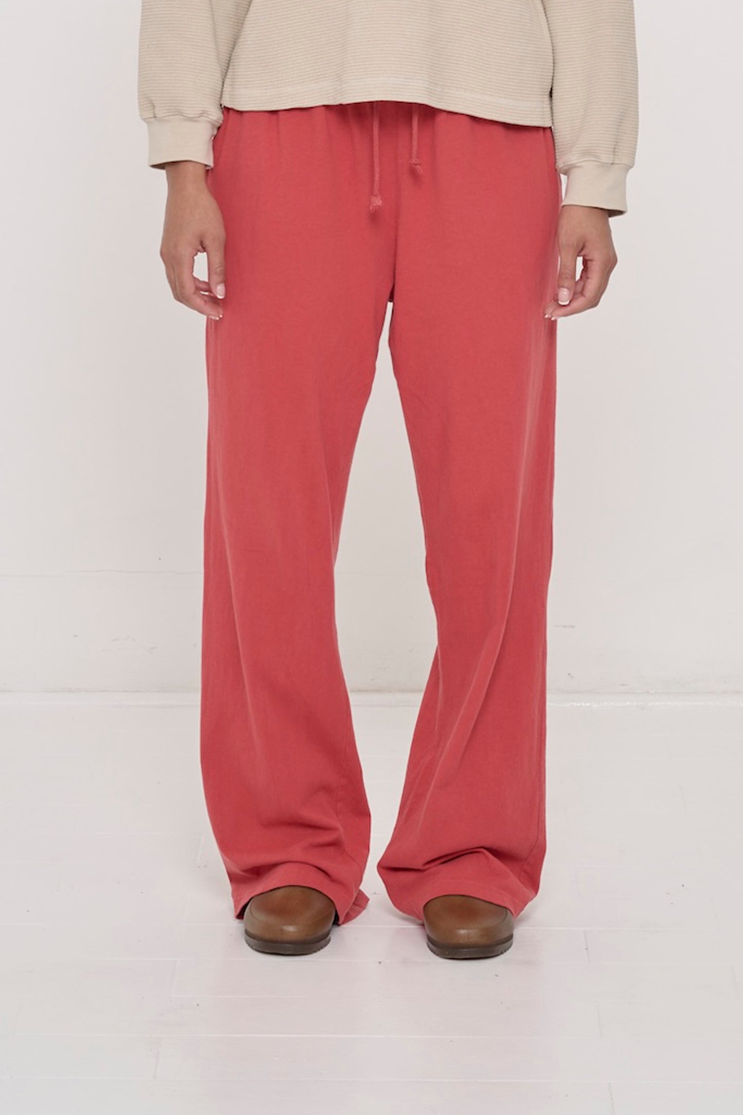 Close-up front view of a person wearing Jerico's Apartment Pants in Cedar, showing elastic waistband and relaxed drape.