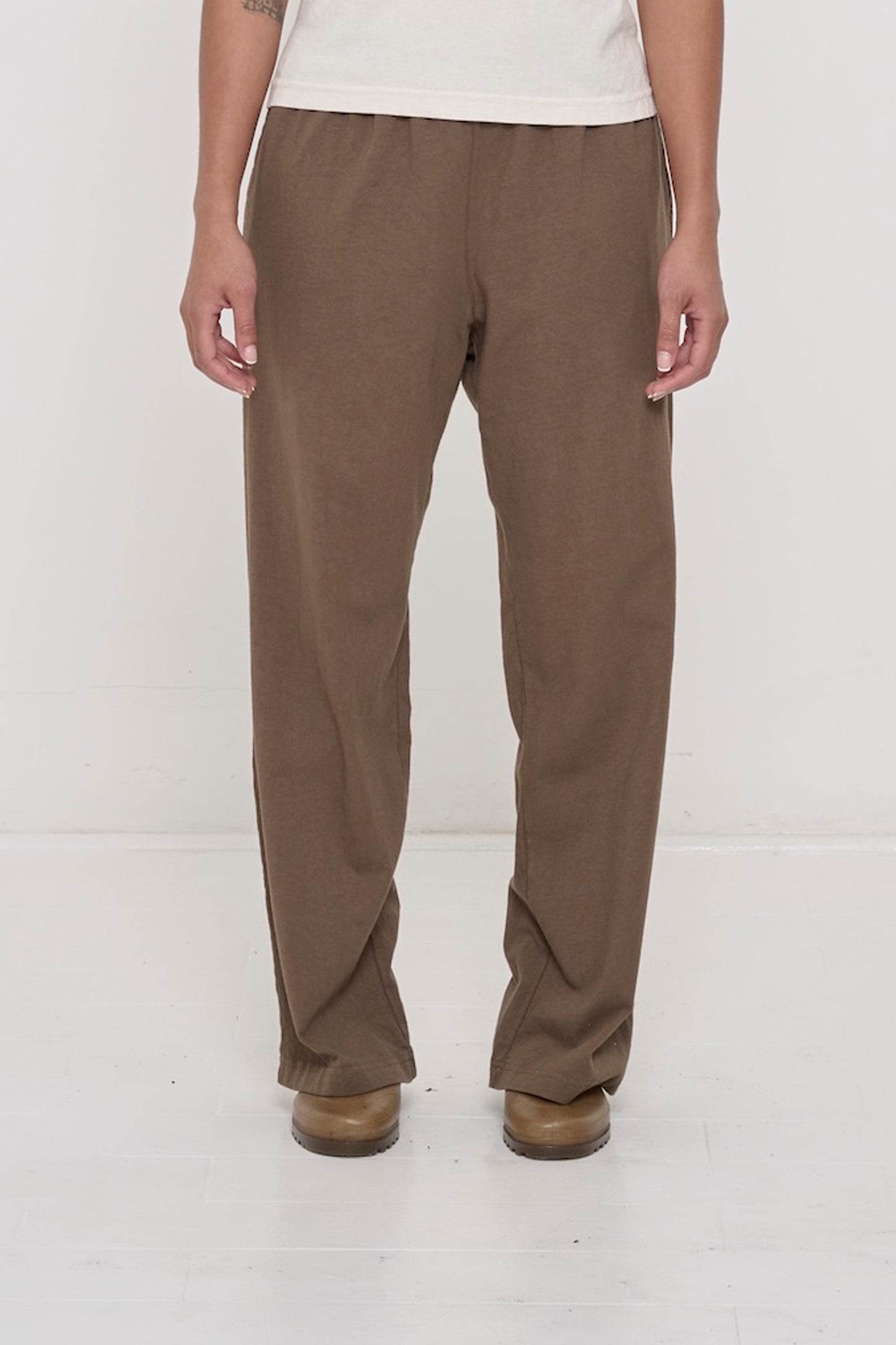 Close-up front view of a person wearing Jerico's Apartment Pants in Dry Soil, showing elastic waistband and relaxed drape.