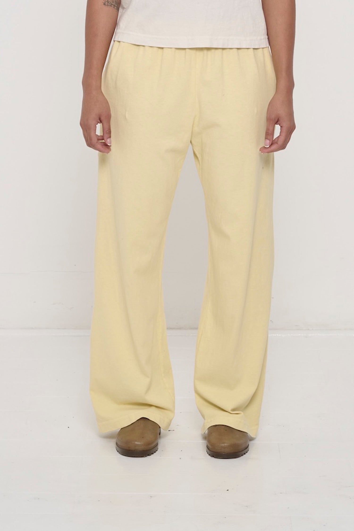 Waist down of a 5'8"person in Size M French Butter Apartment Pants. Relaxed drape. Hem at bottom of the heels.