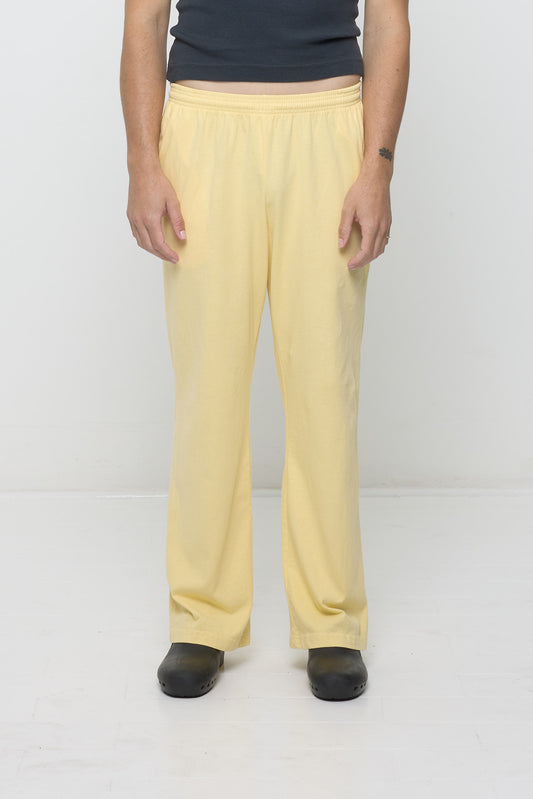 Close-up front view of a person wearing Jerico's Apartment Pants in French Butter yellow, highlighting the elastic waistband and relaxed drape, worn with moderate ease in the hips.