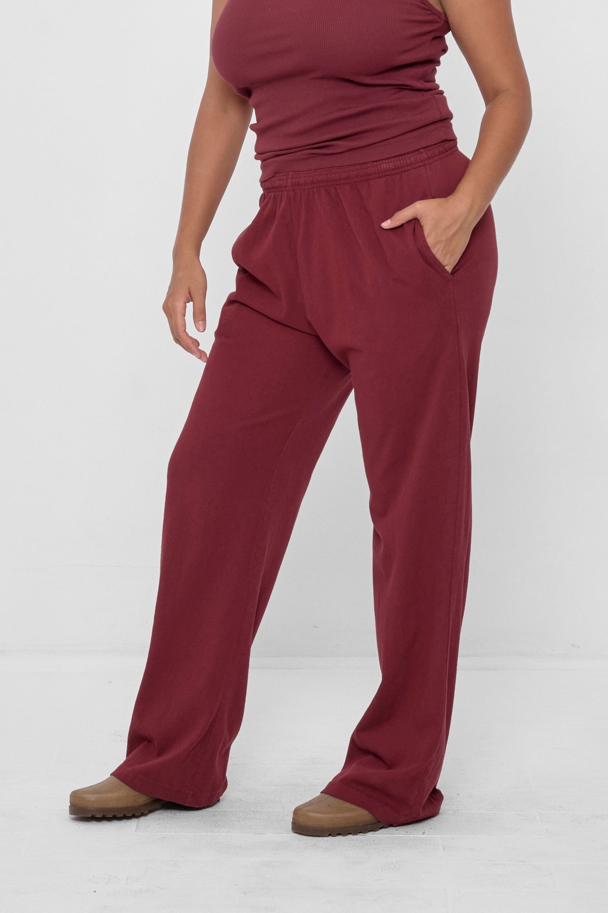 Apartment Pants in Garnet – skewed front view, model's hand in her pocket