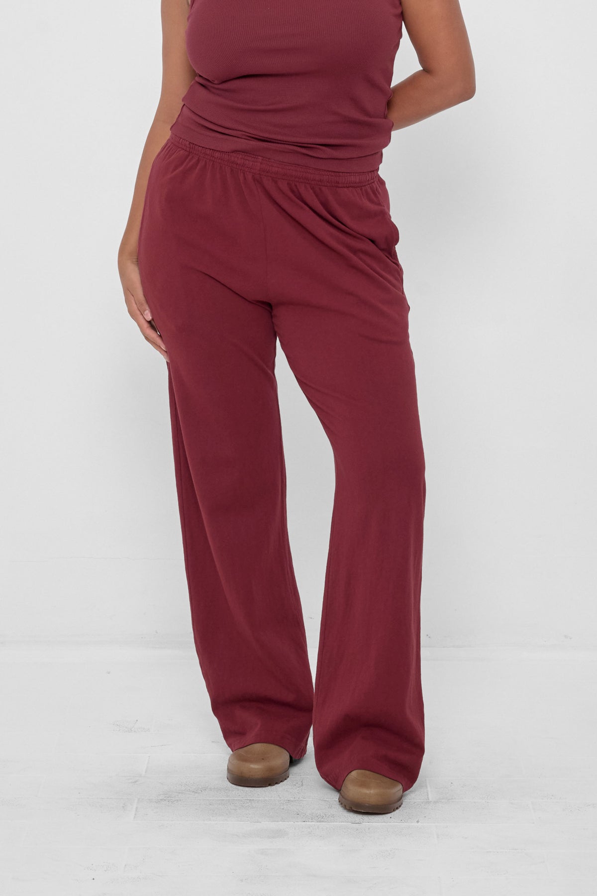 Apartment Pants in Garnet – front view, model's hands to the side and behind her back