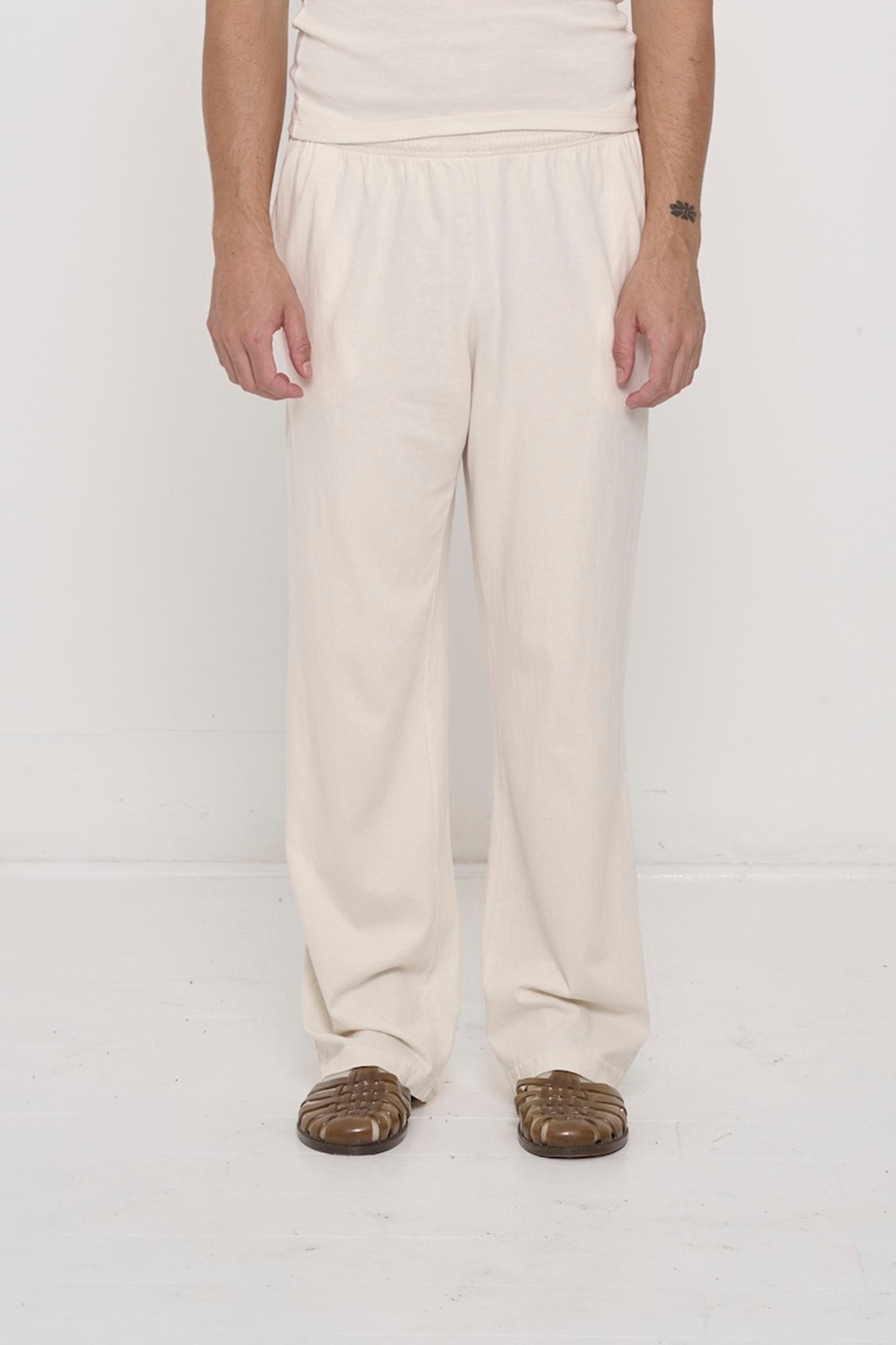 Waist down of a 6' person in Size L Scour Apartment Pants. Relaxed drape. Hem pools a bit at the heel.