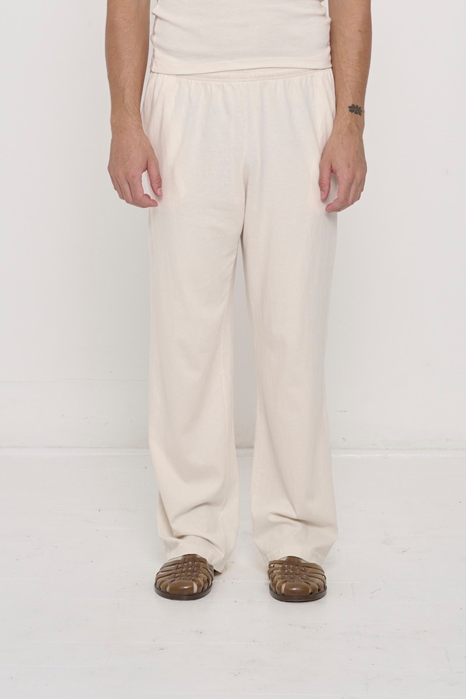 Waist down of a 6' person in Size L Scour Apartment Pants. Relaxed drape. Hem pools a bit at the heel.