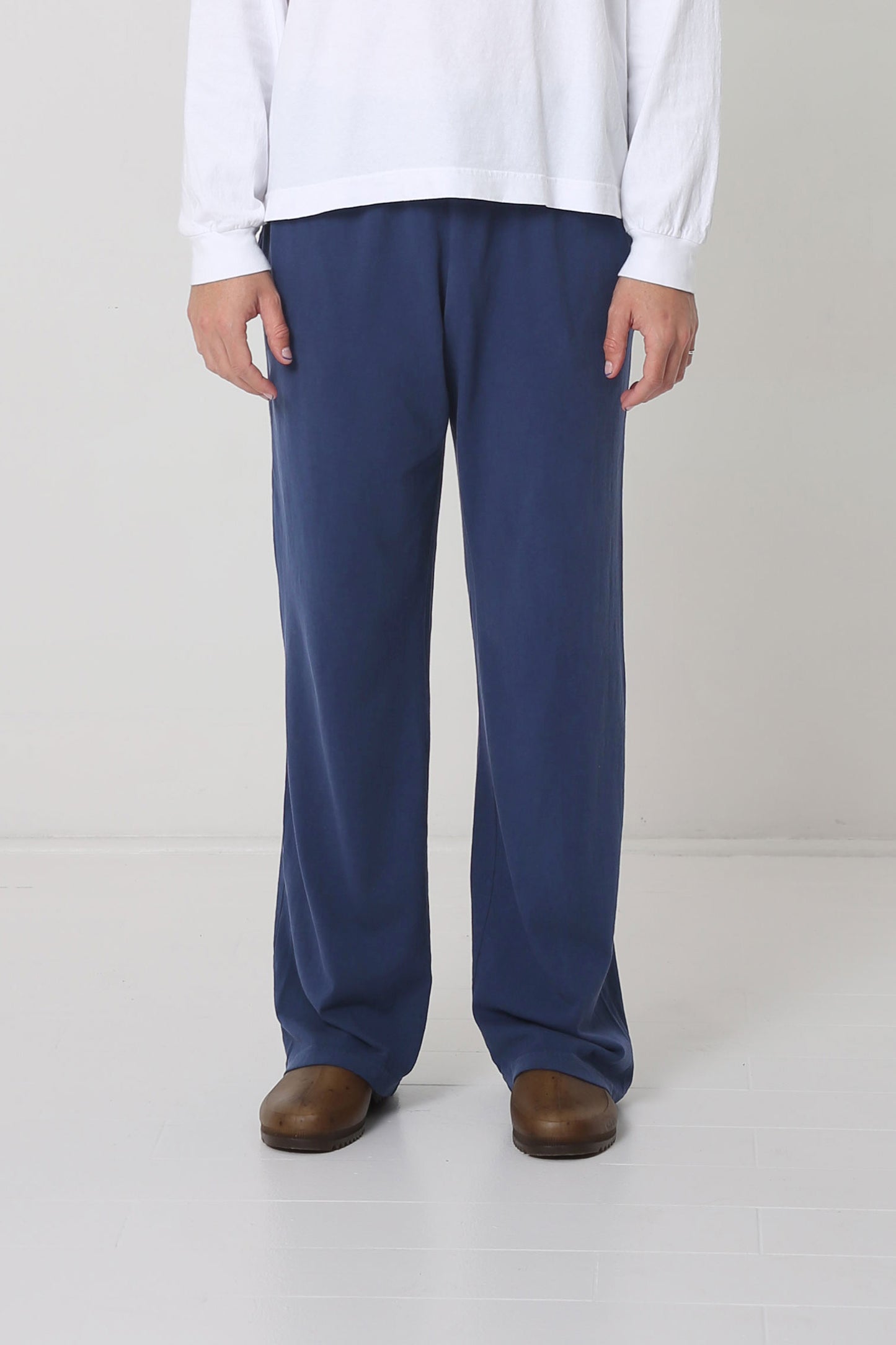 Waist down of a 6' person in Size L Washed Navy Apartment Pants. Hem ends below the heel.