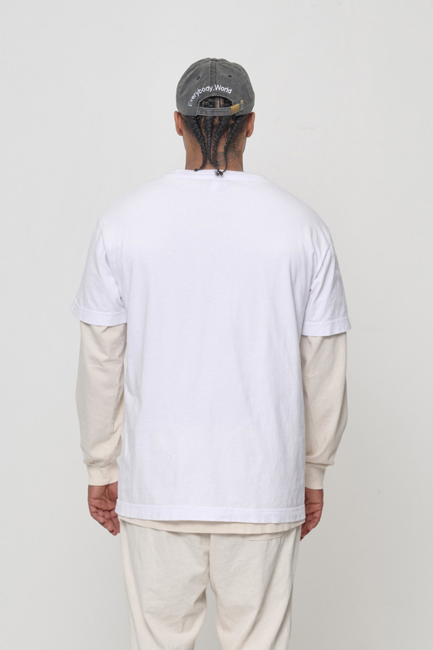 Back view on a man: 'Everybody,World' embroidered in an arc above the adjustable closure. 