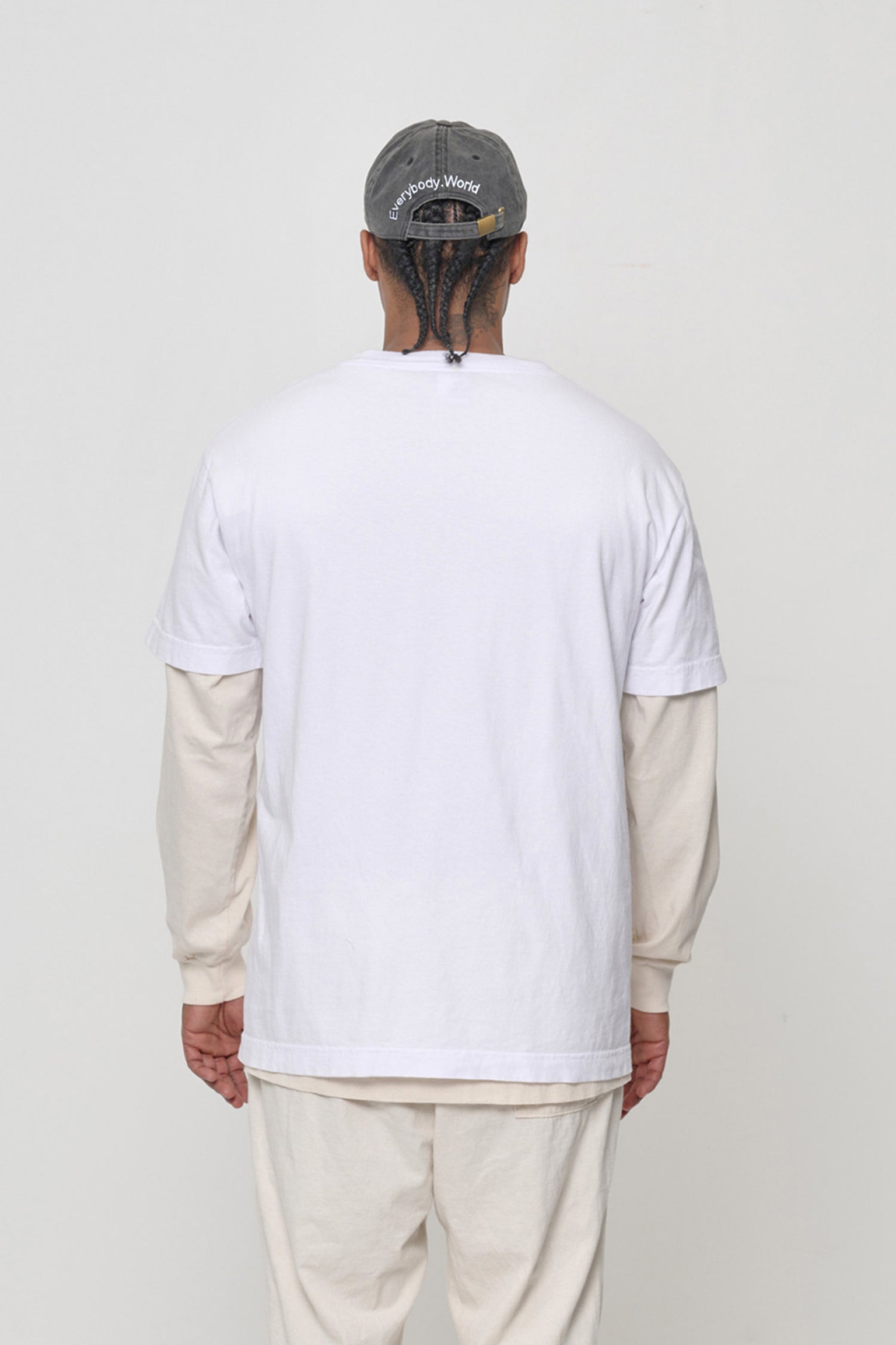 Back view on a man: 'Everybody,World' embroidered in an arc above the adjustable closure. 