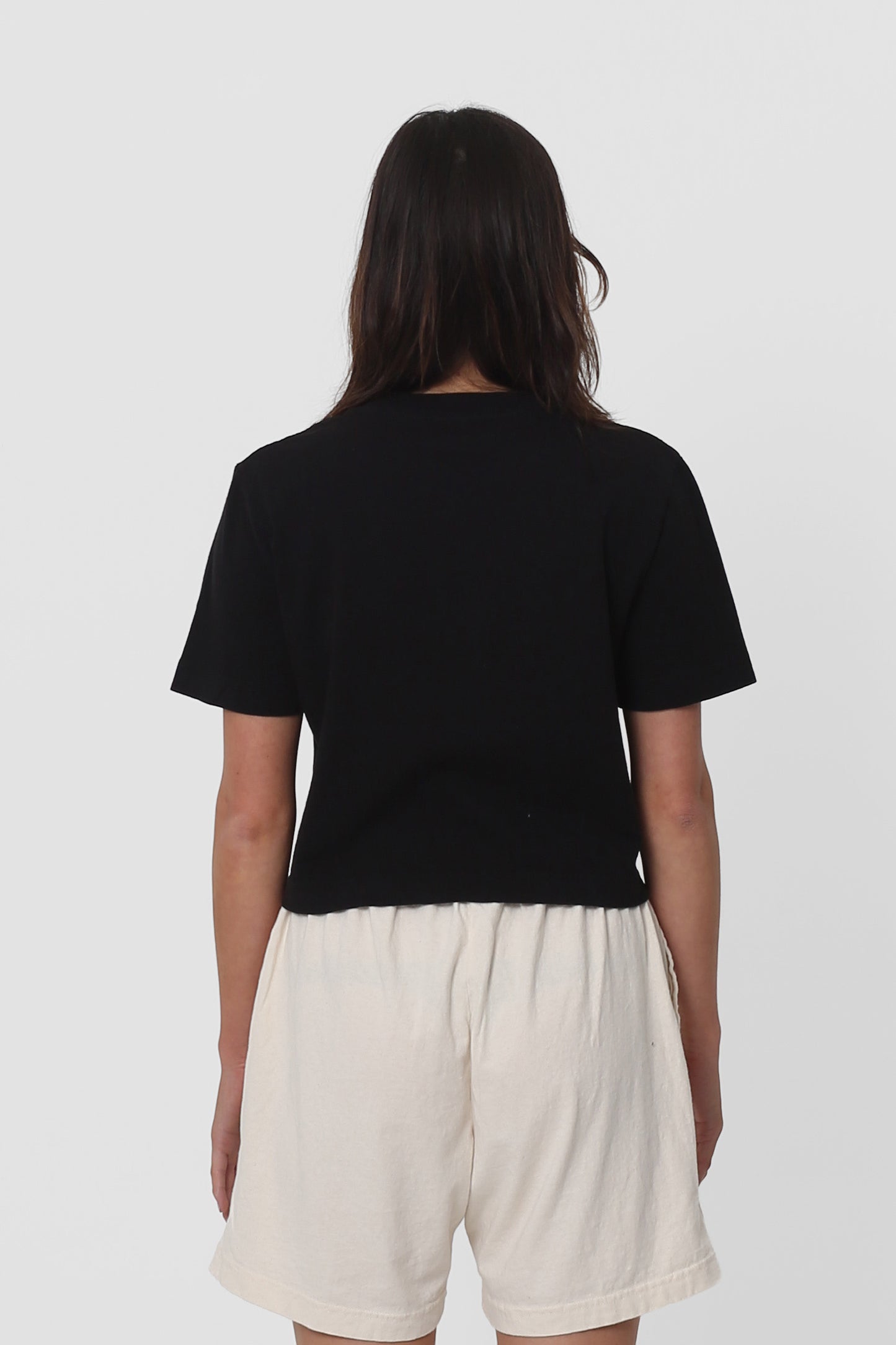 Back view with fabric folds showing relaxed fit at lower back.
