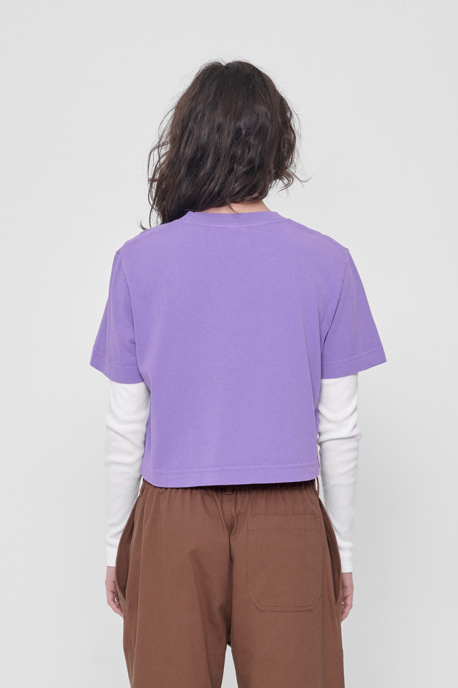 Back view with fabric folds showing relaxed fit at lower back.