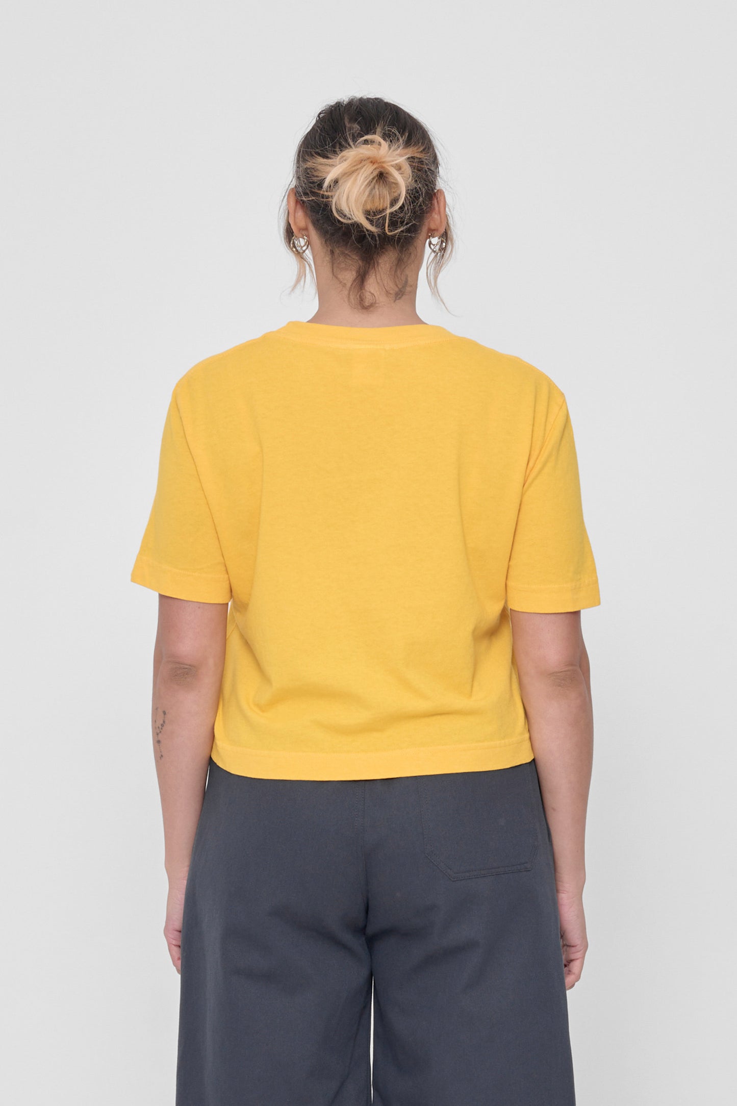 Back view with fabric folds showing relaxed fit at lower back.