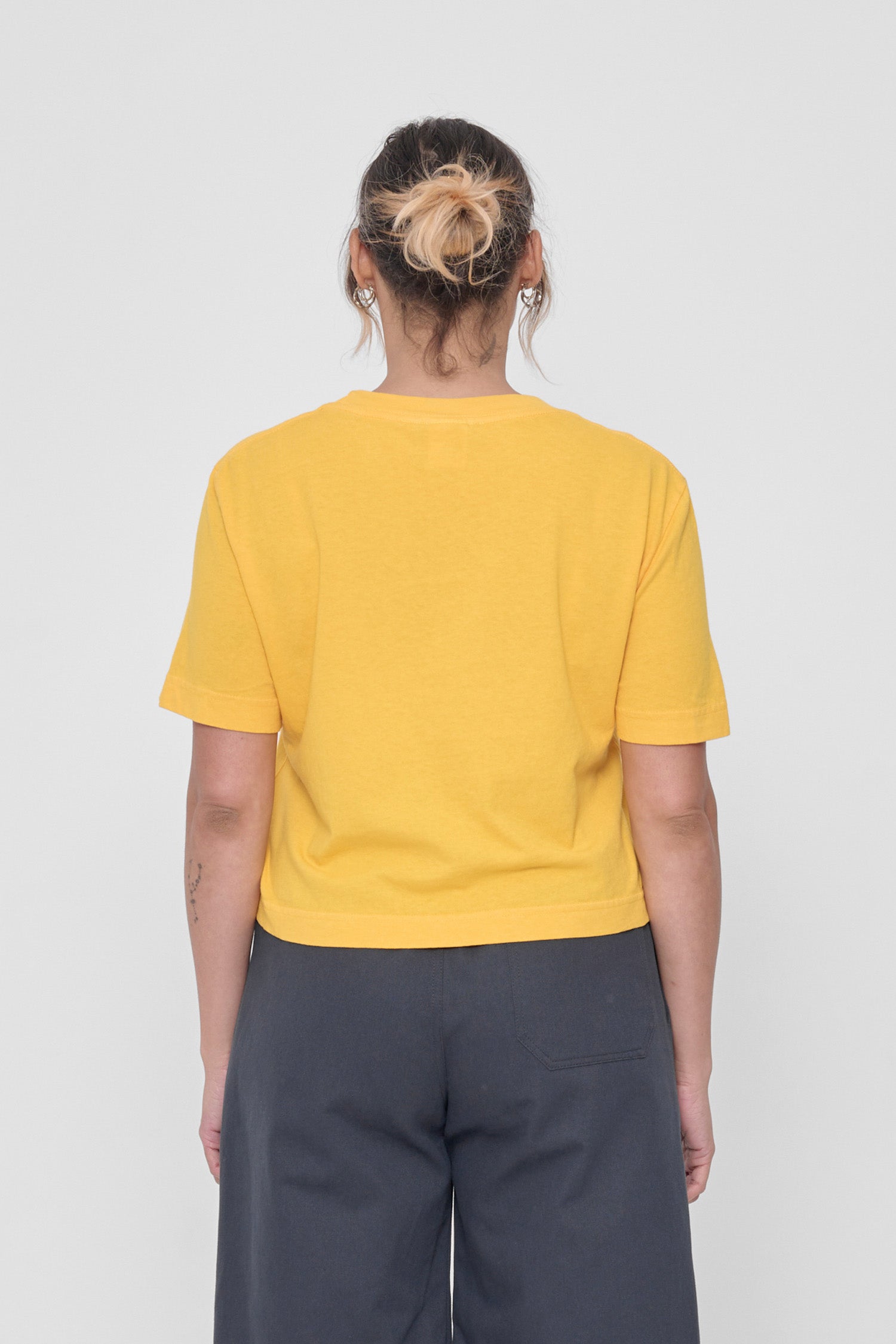 Back view with fabric folds showing relaxed fit at lower back.