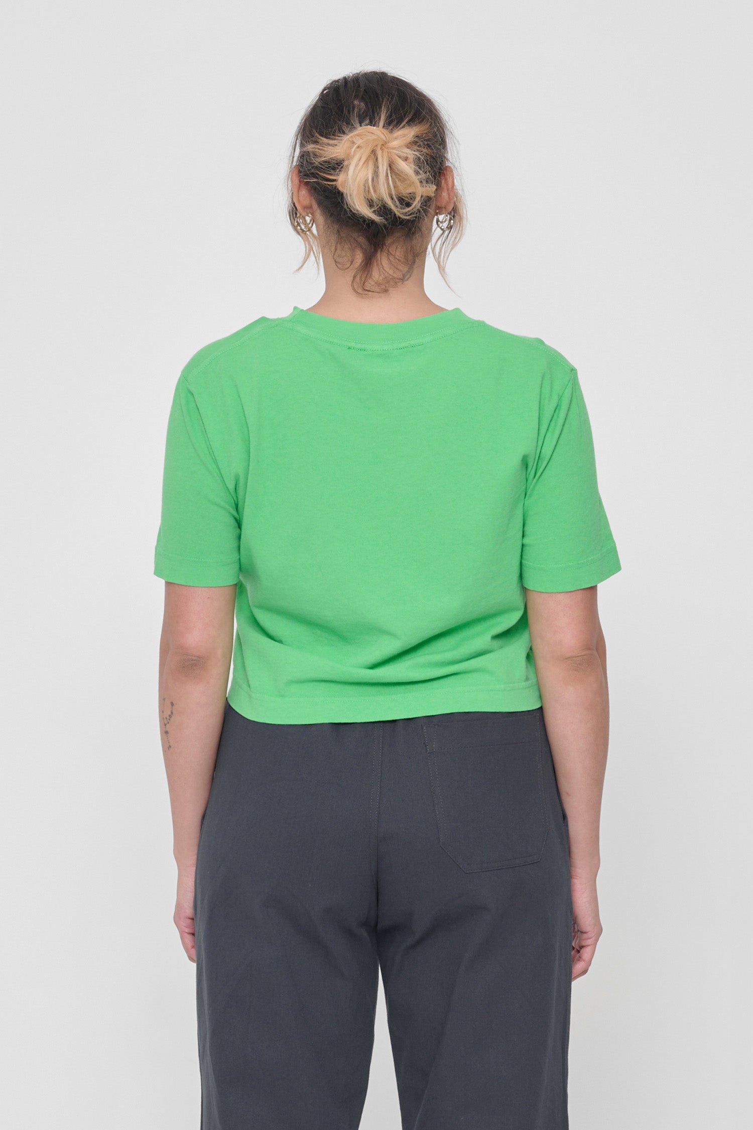 Back view with fabric folds showing relaxed fit at lower back.