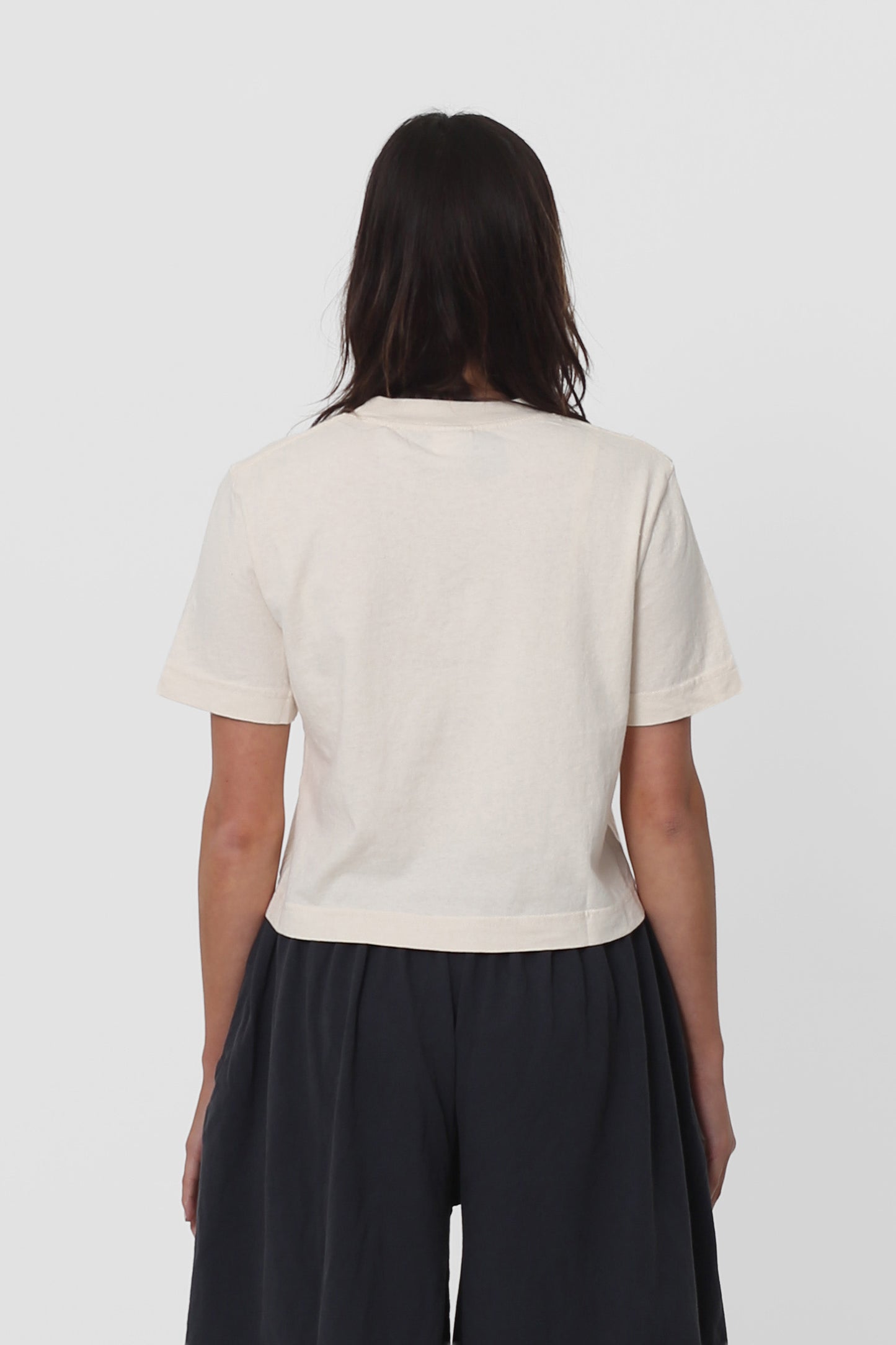 Back view with fabric folds showing relaxed fit at lower back.