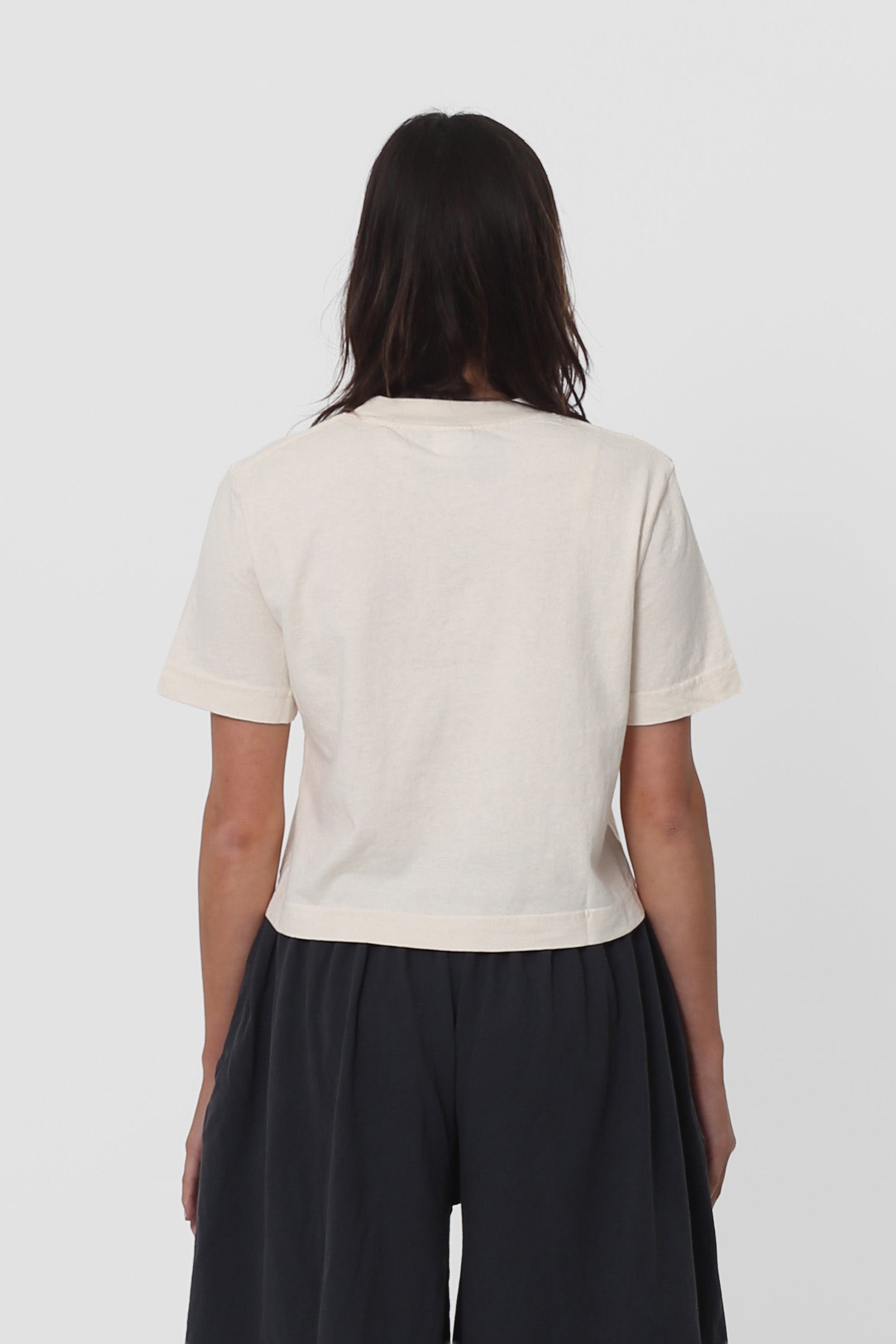 Back view with fabric folds showing relaxed fit at lower back.