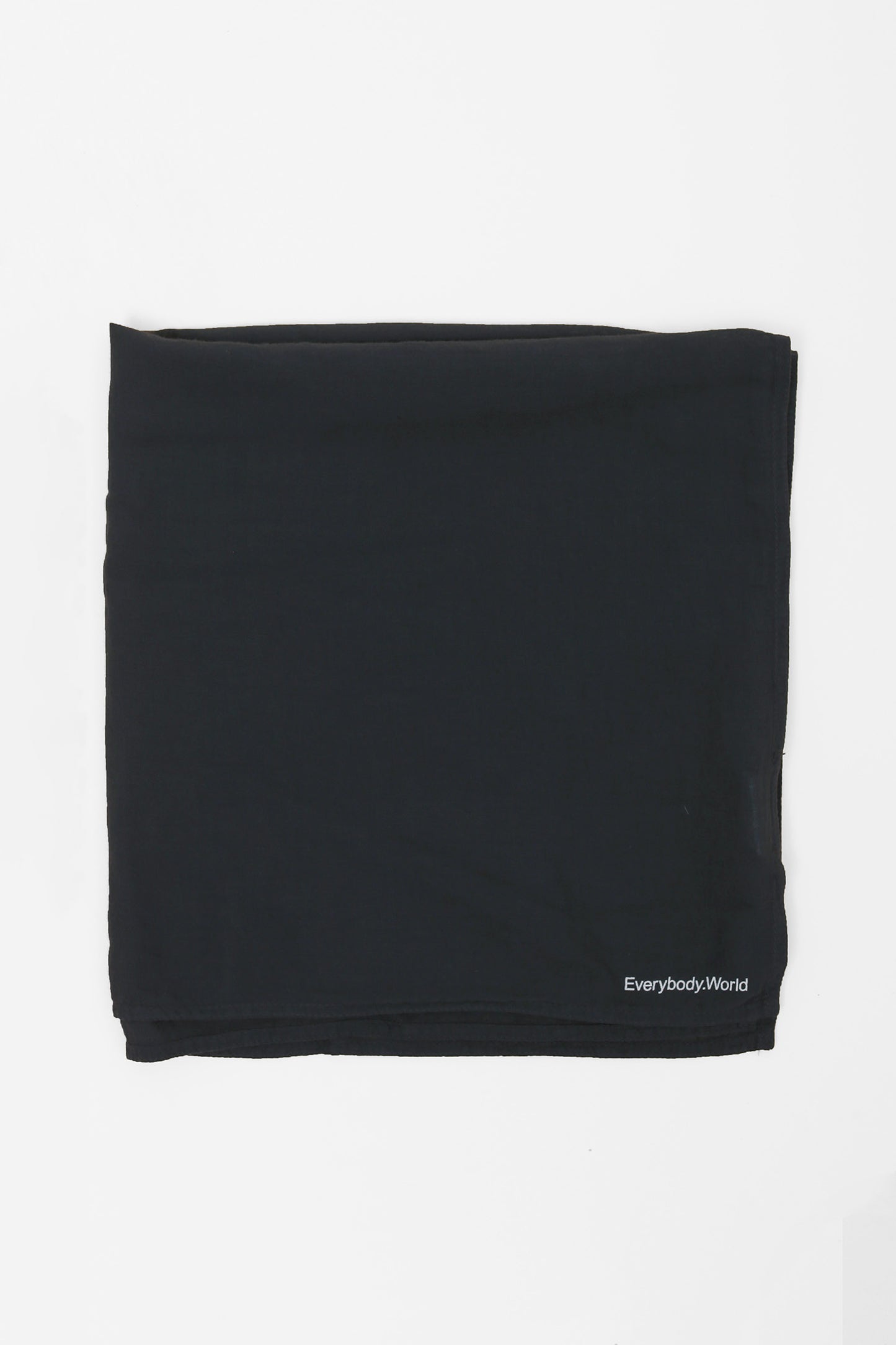 Flat lay of Slate bandana scarf with 'Everybody World' branding on a light gray background
