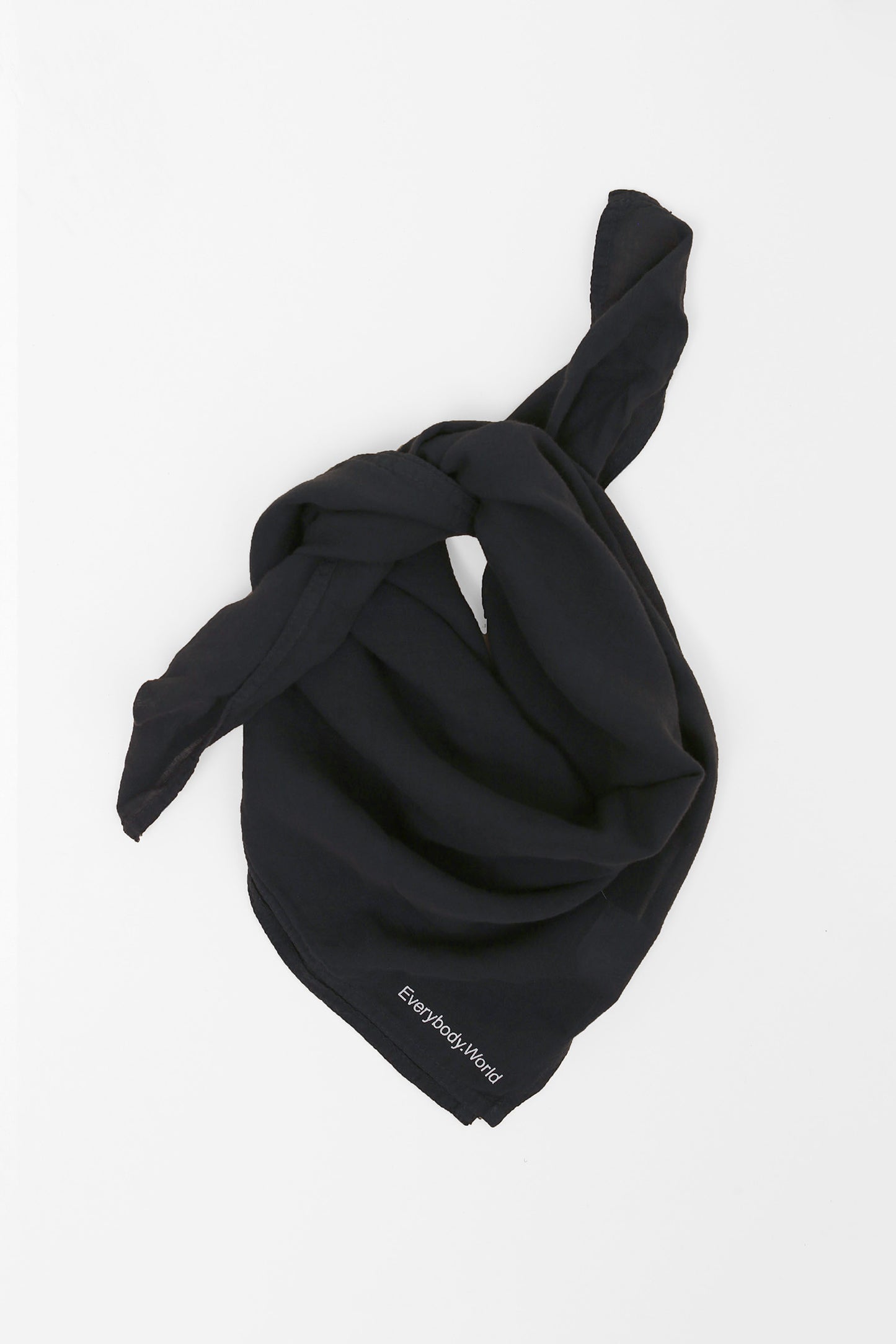 Slate colored scarf tied in a knot on a light gray background.