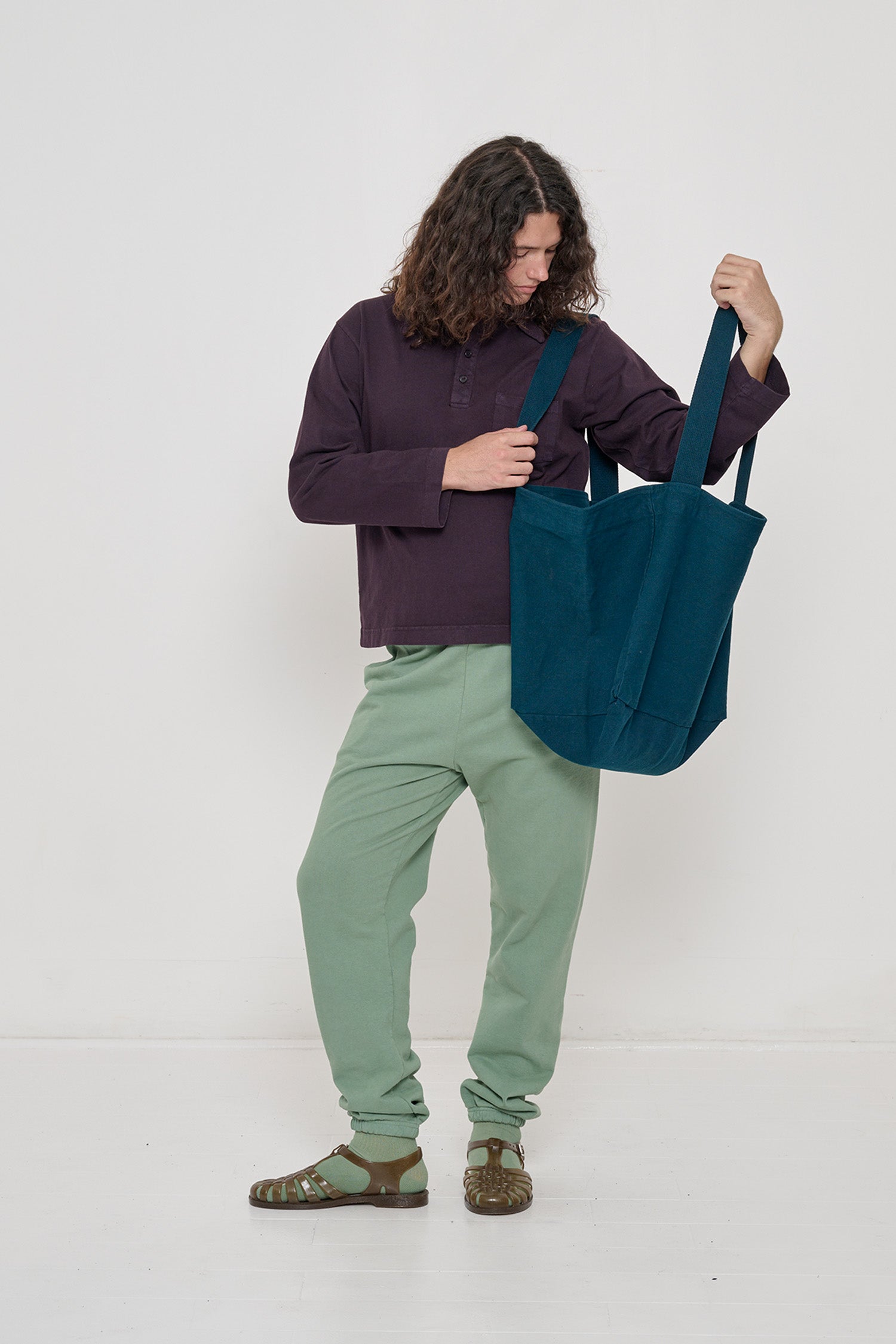 Person holding Big Tote in Juniper dark teal on their shoulder, showing fabric folds and the flexibility of the bag.