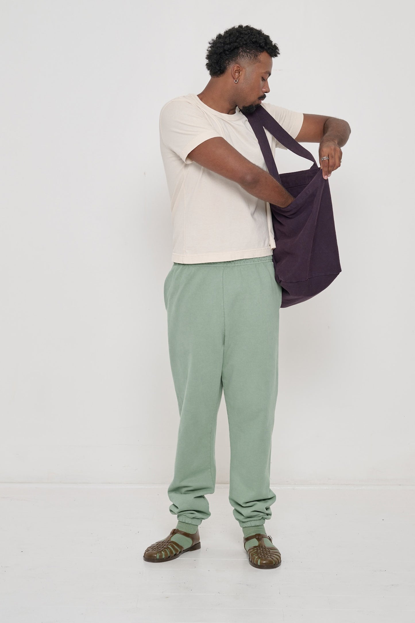 Man holding Big Tote in Mulberry dark purple on his shoulder, showing fabric folds and the flexibility of the bag.