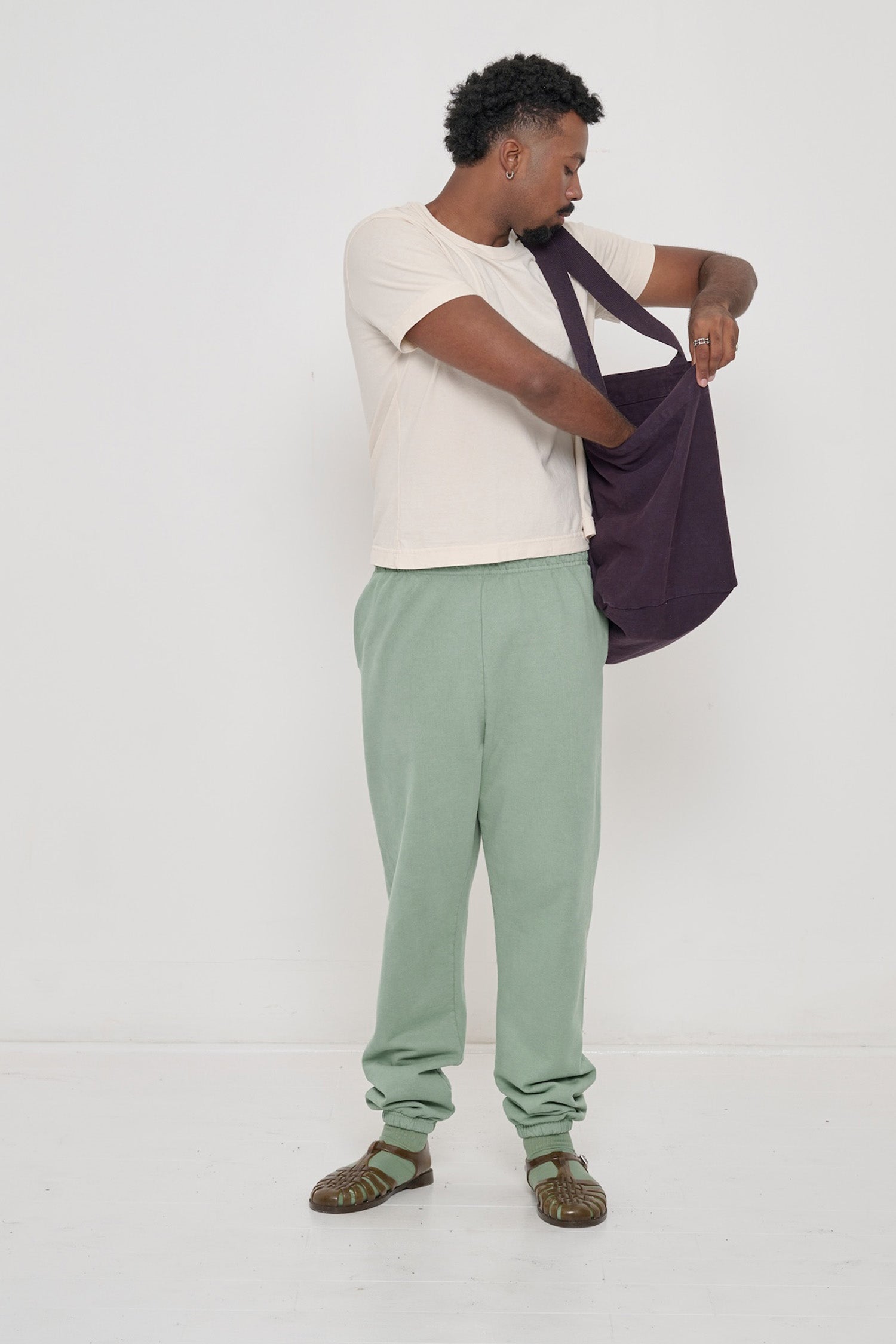 Man holding Big Tote in Mulberry dark purple on his shoulder, showing fabric folds and the flexibility of the bag.