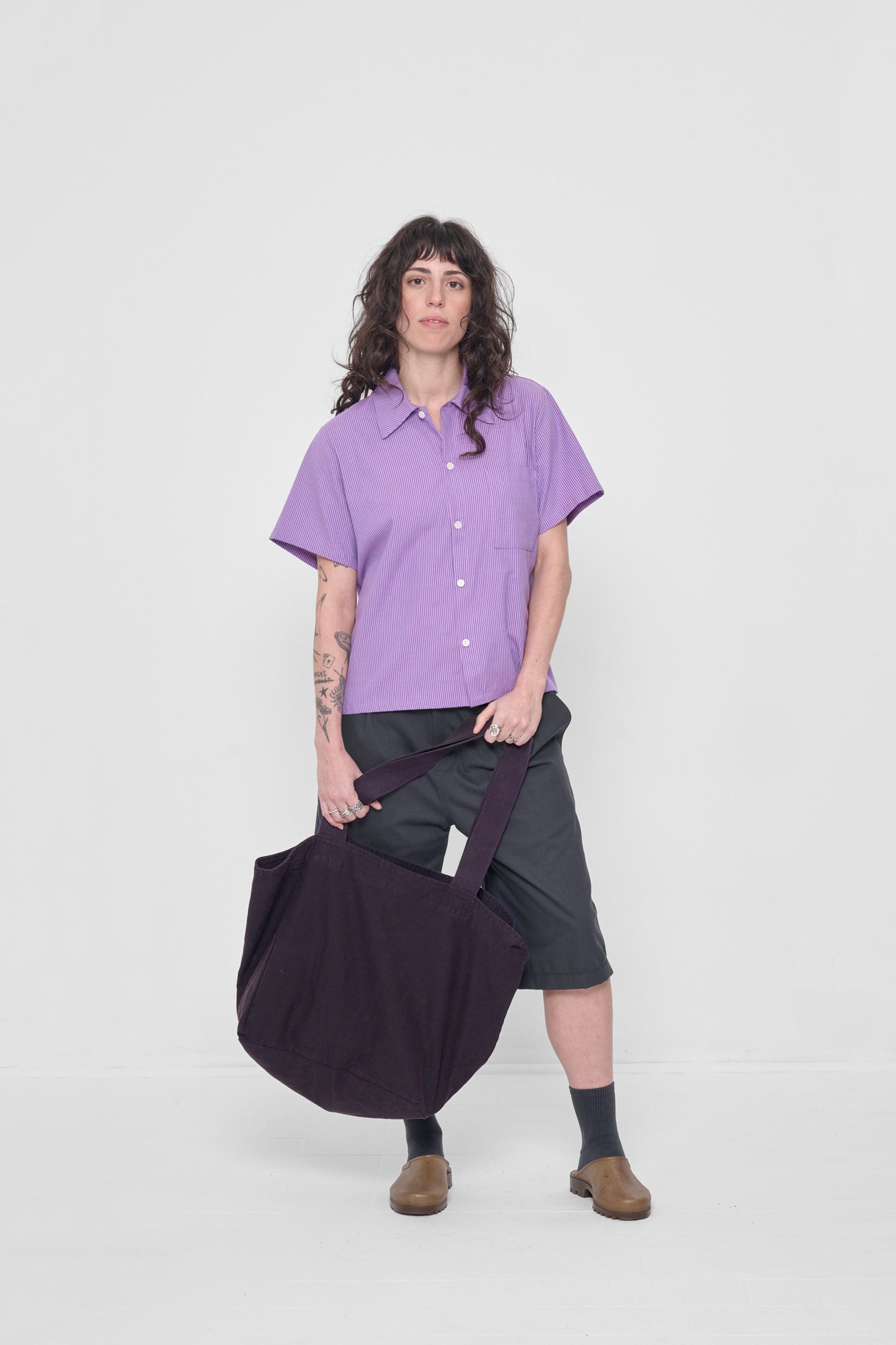 Woman holding Big Tote in front of her showing that it is a long as her lower leg. 