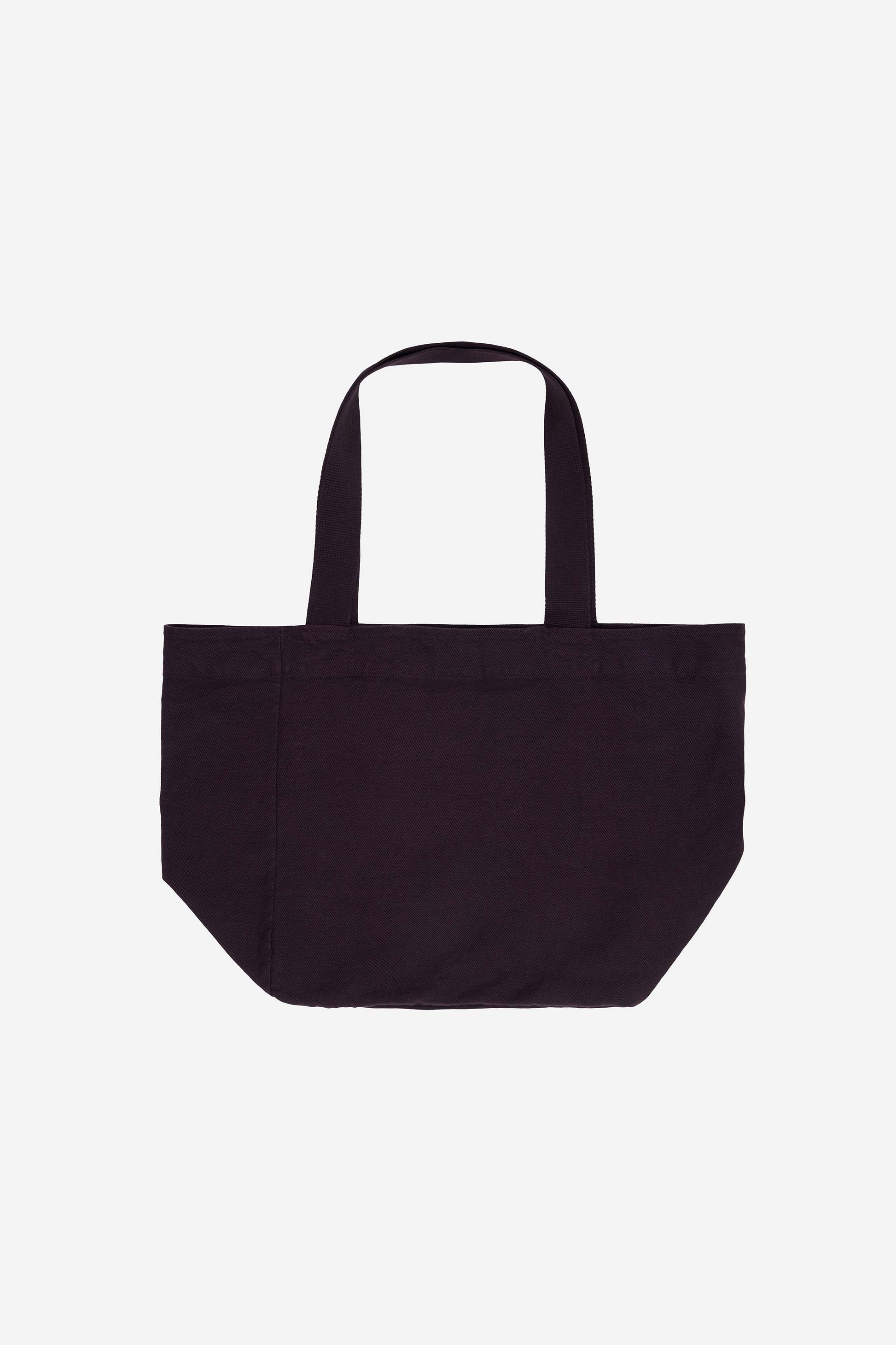 Flat lay of Big Tote in Mulberry dark purple, showing depth, stitching, and web straps.