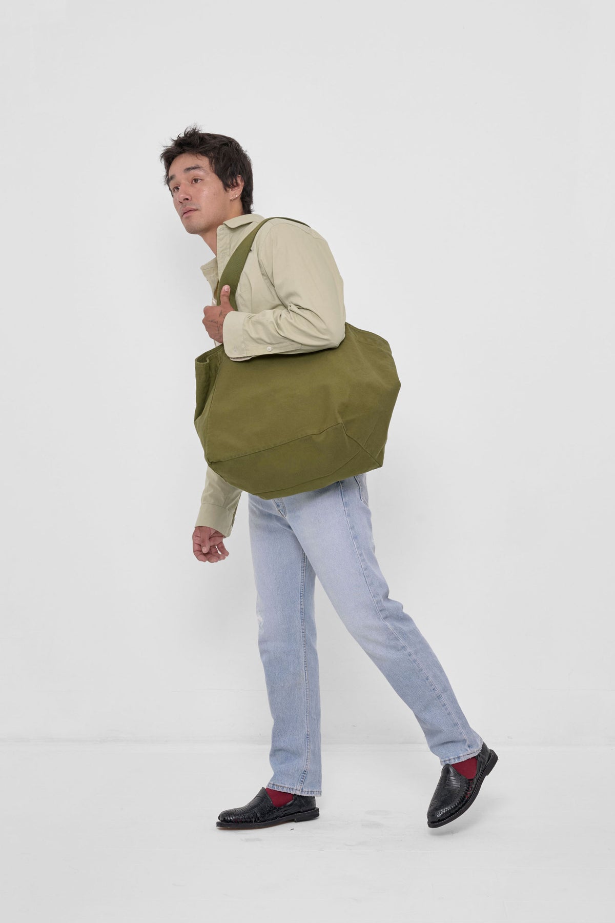 Big Tote in Olive – carried on model's shoulder, full-body side view showing scale of bag's width.