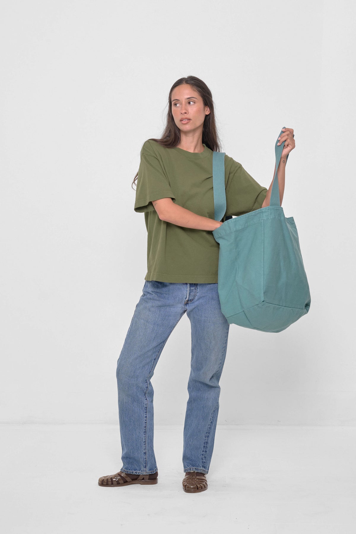 Big Tote in Oyster – held open with one strap on model's shoulder, one strap in model's hand
