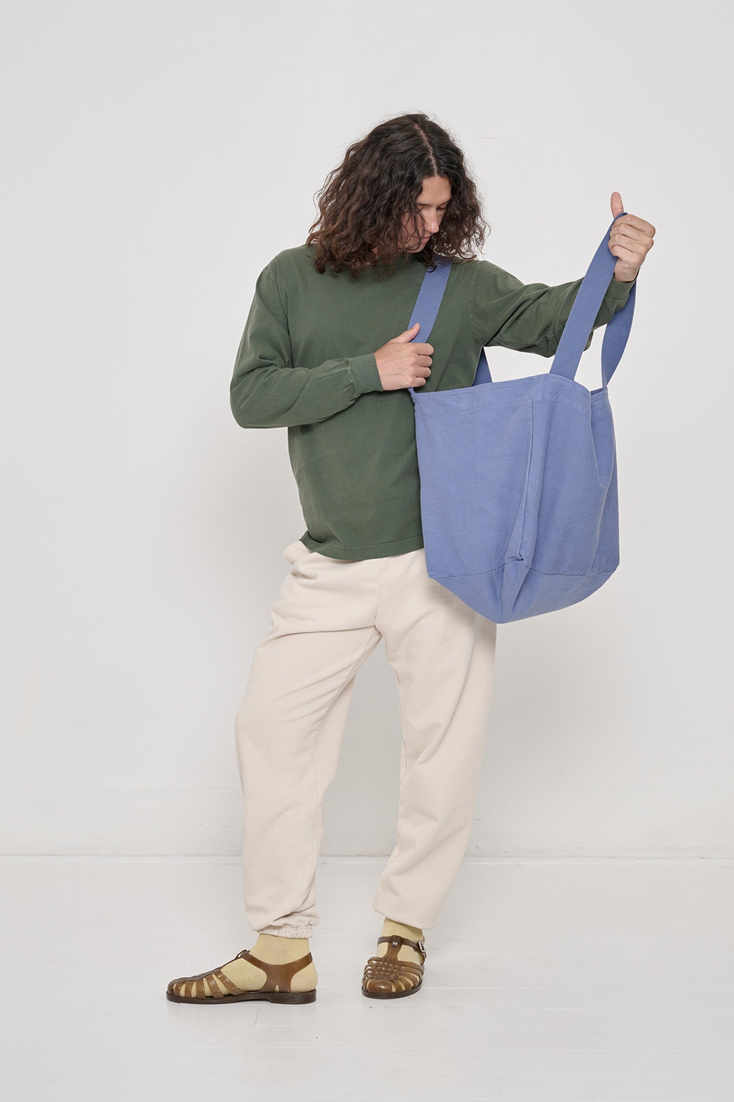 Person holding Big Tote in Periwinkle light blue-purple on their shoulder, showing fabric folds and the flexibility of the bag.