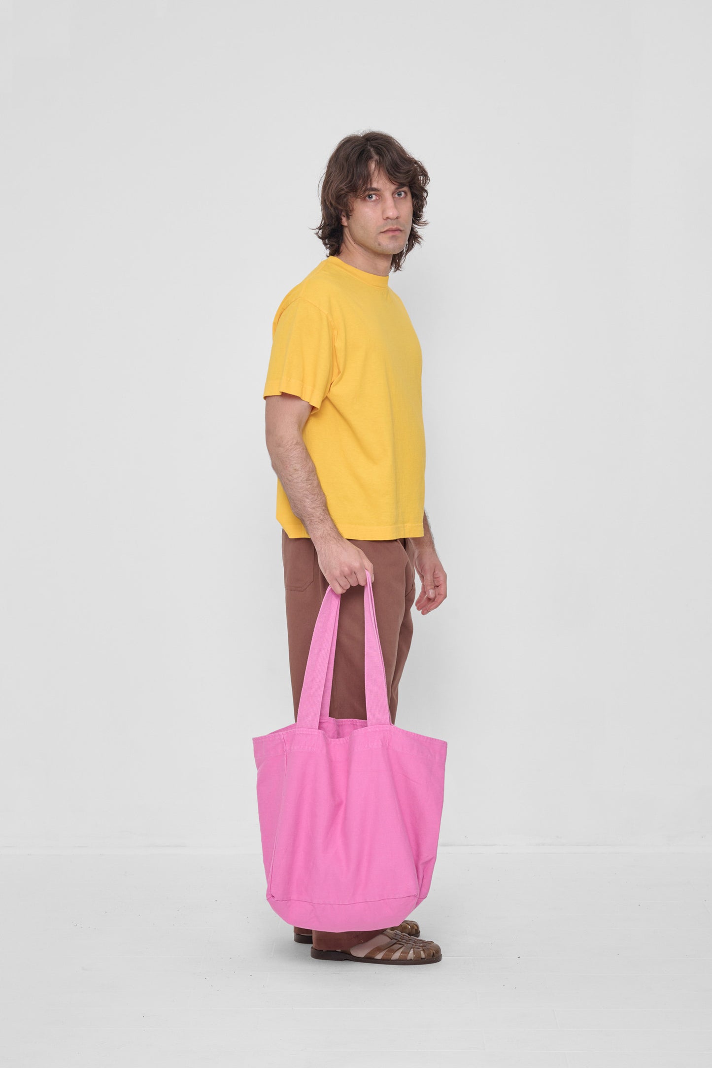Man holding Big Tote at his side showing that the body spans from his knee to the ground.