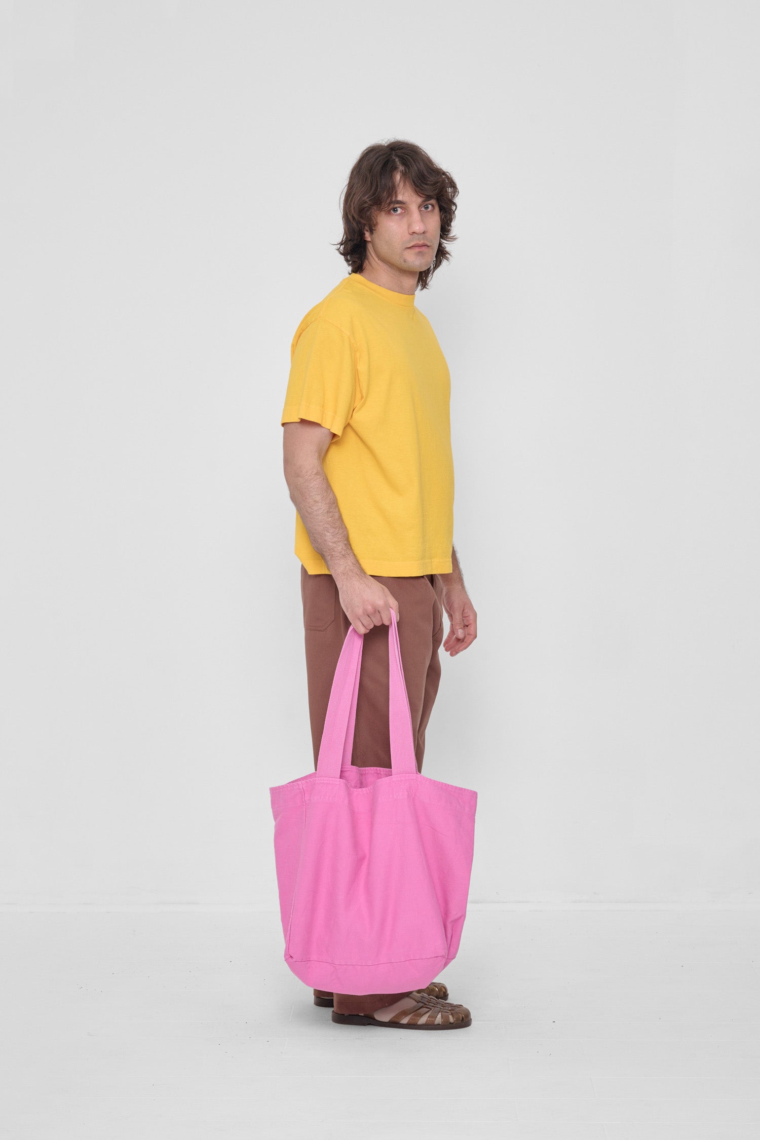 Man holding Big Tote at his side showing that the body spans from his knee to the ground.