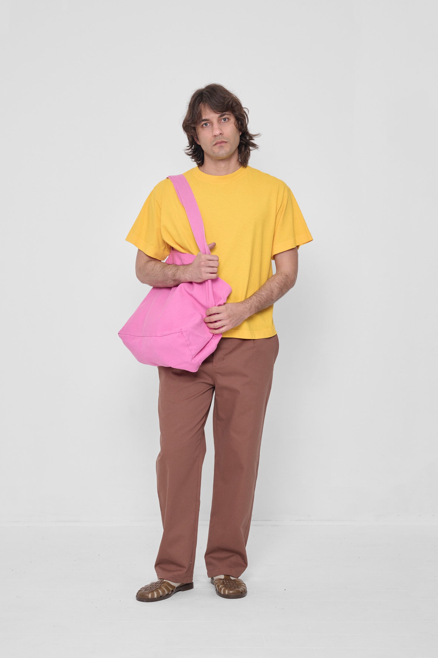 Man holding it over his shoulder, showing that the bag opening begins at his mid-torso.