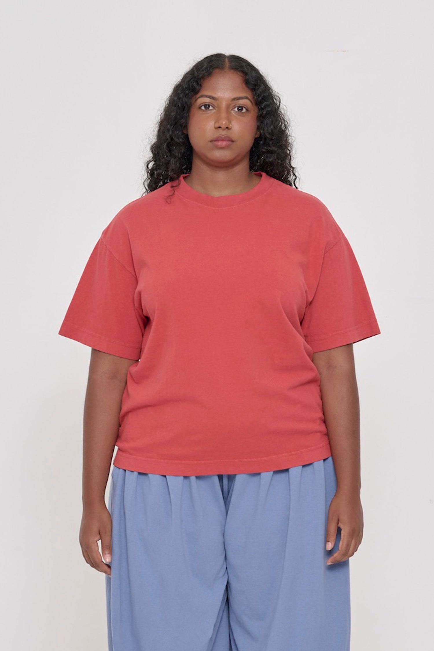 Front view of a 5'8" woman wearing a Cedar (orange red) Boxier Trash Tee in size M. Hem at mid hip.