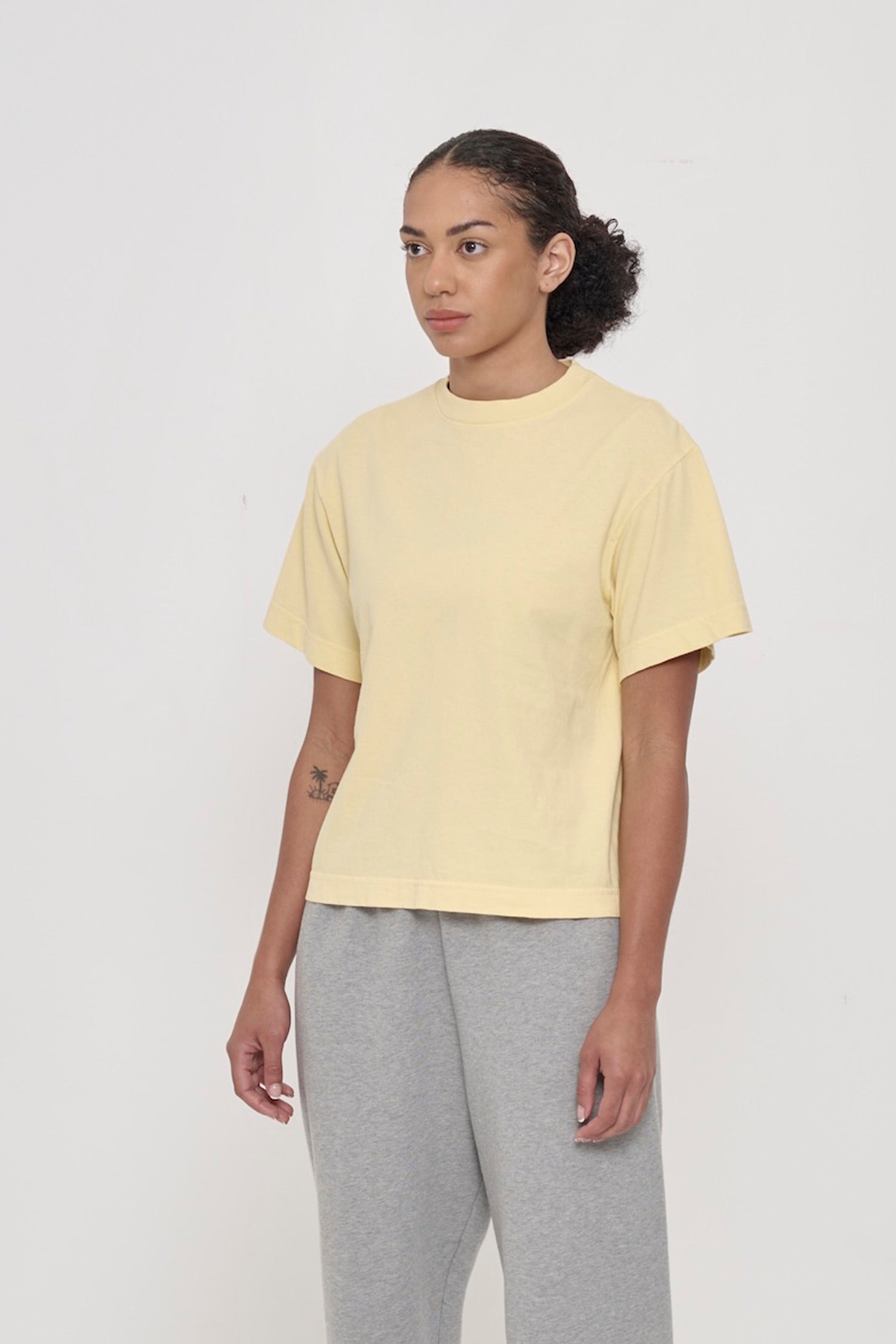 45-degree front view of a woman in a French Butter Boxier Trash Tee showing wide short sleeves and no side seams.