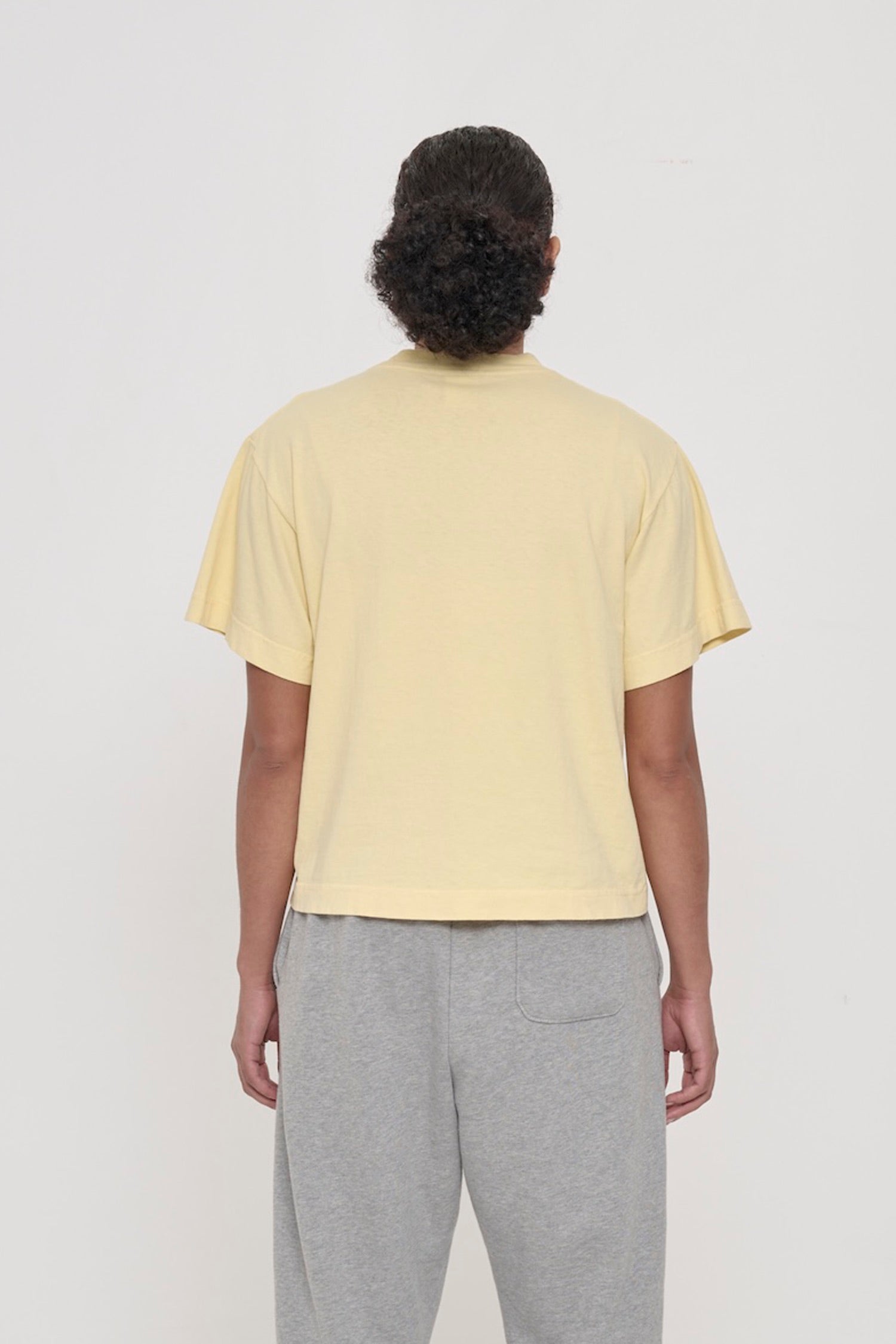 Back view: a woman in a French Butter Boxier Trash Tee showing fabric drape and relaxed fit throughout.