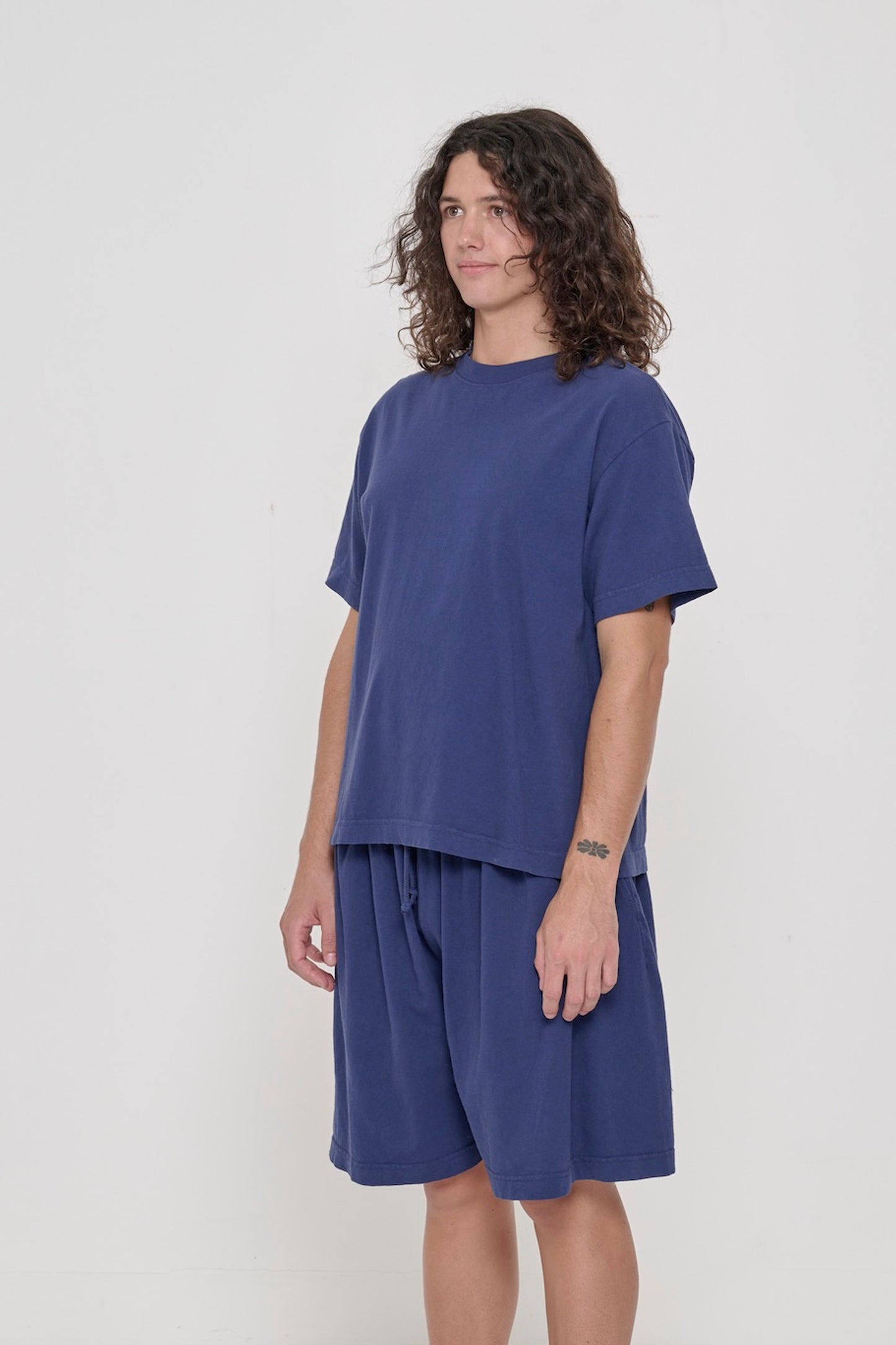 45-degree front view of a person in a Washed Navy Boxier Trash Tee showing wide short sleeves and no side seams.