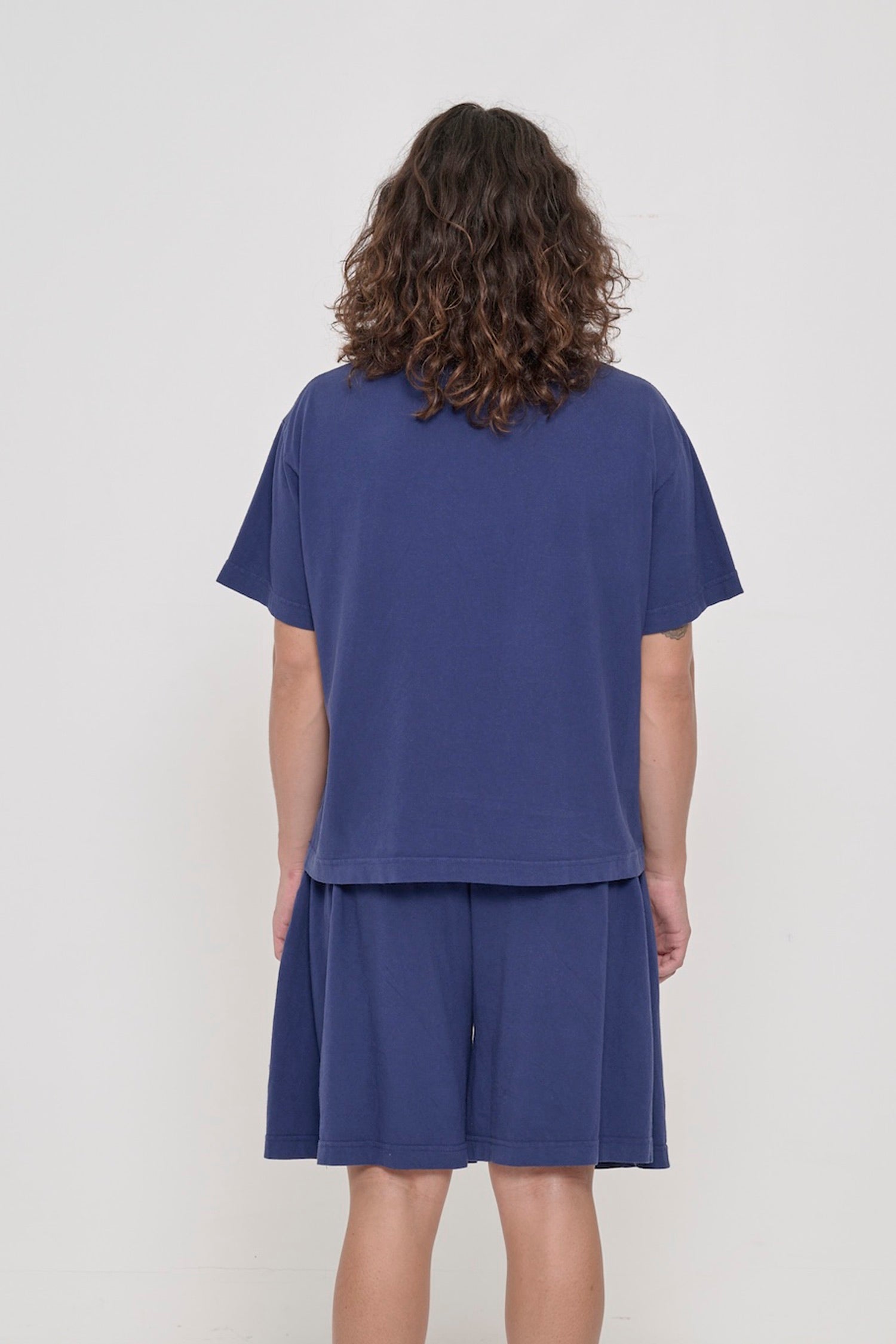 Back view: a person in a Washed Navy Boxier Trash Tee showing fabric drape and relaxed fit throughout.