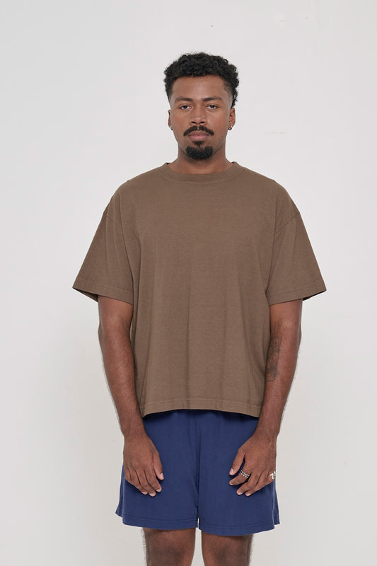 A 6'2" man in Dry Soil brown Boxier Trash Tee. Bottom hem at his lower hip.