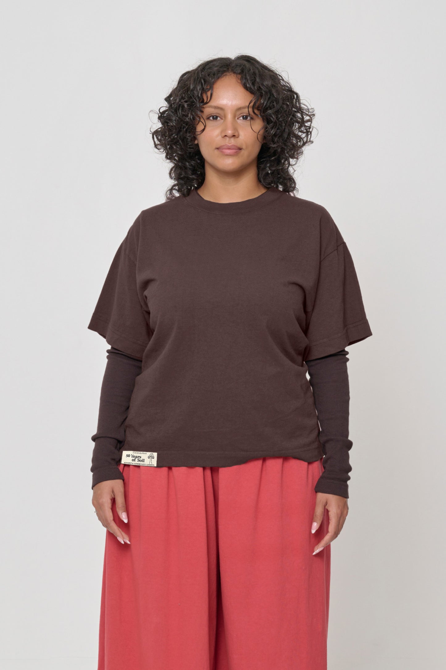5'7" woman in a size M Boxier Trash Tee. Hem at her lower middle hip.