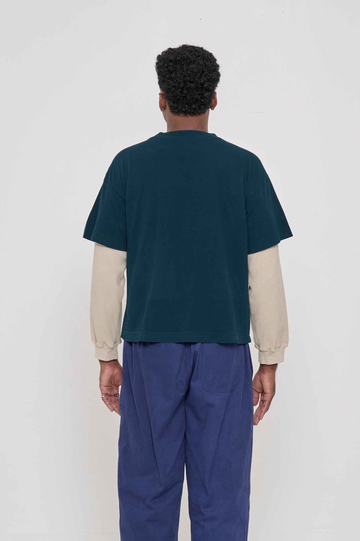 Back view of Boxier Trash Tee in Juniper dark teal showing fabric drape and relaxed fit throughout.